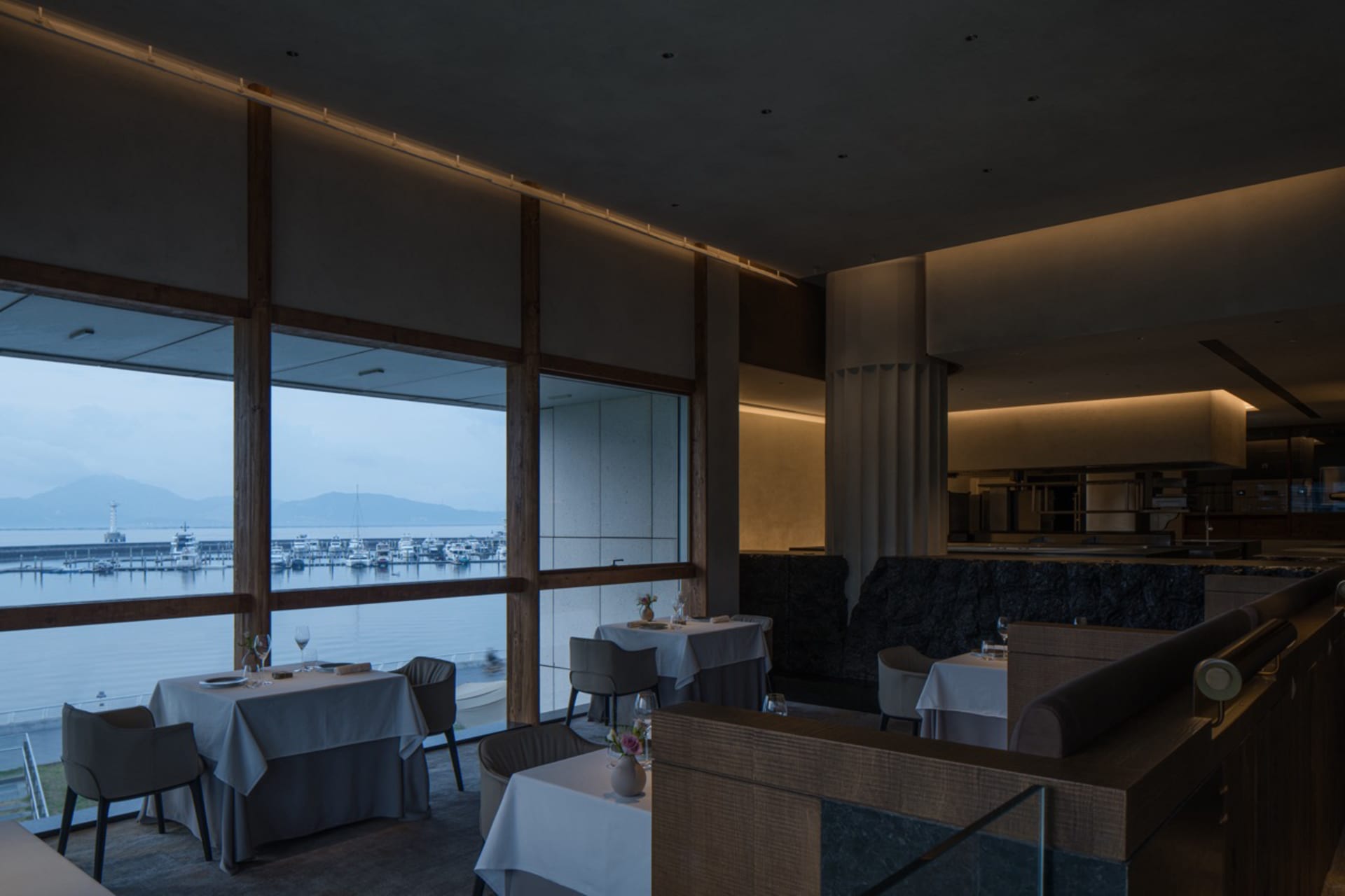 現代餐廳室內空間,玻璃窗外可眺望海洋景色。