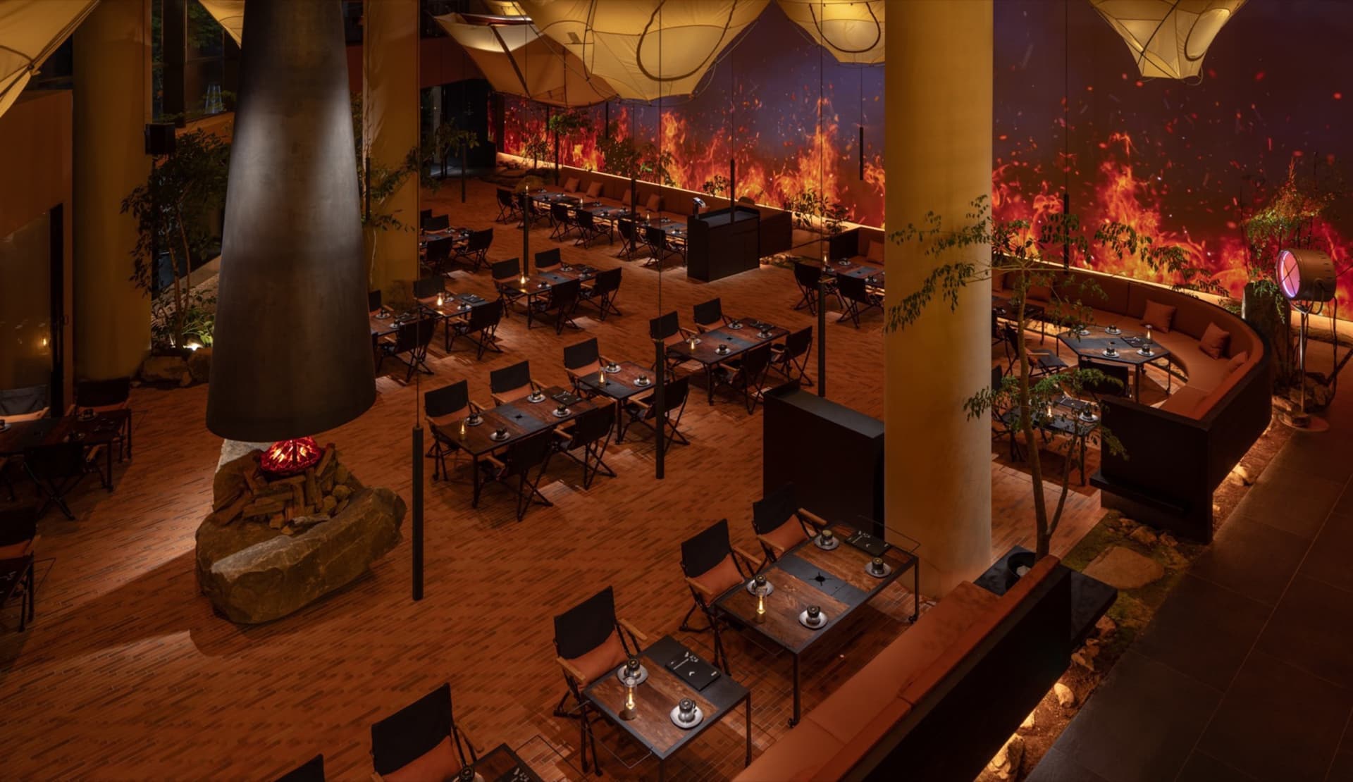 Modern dining hall with wooden floors, metal furniture, and glass elements.