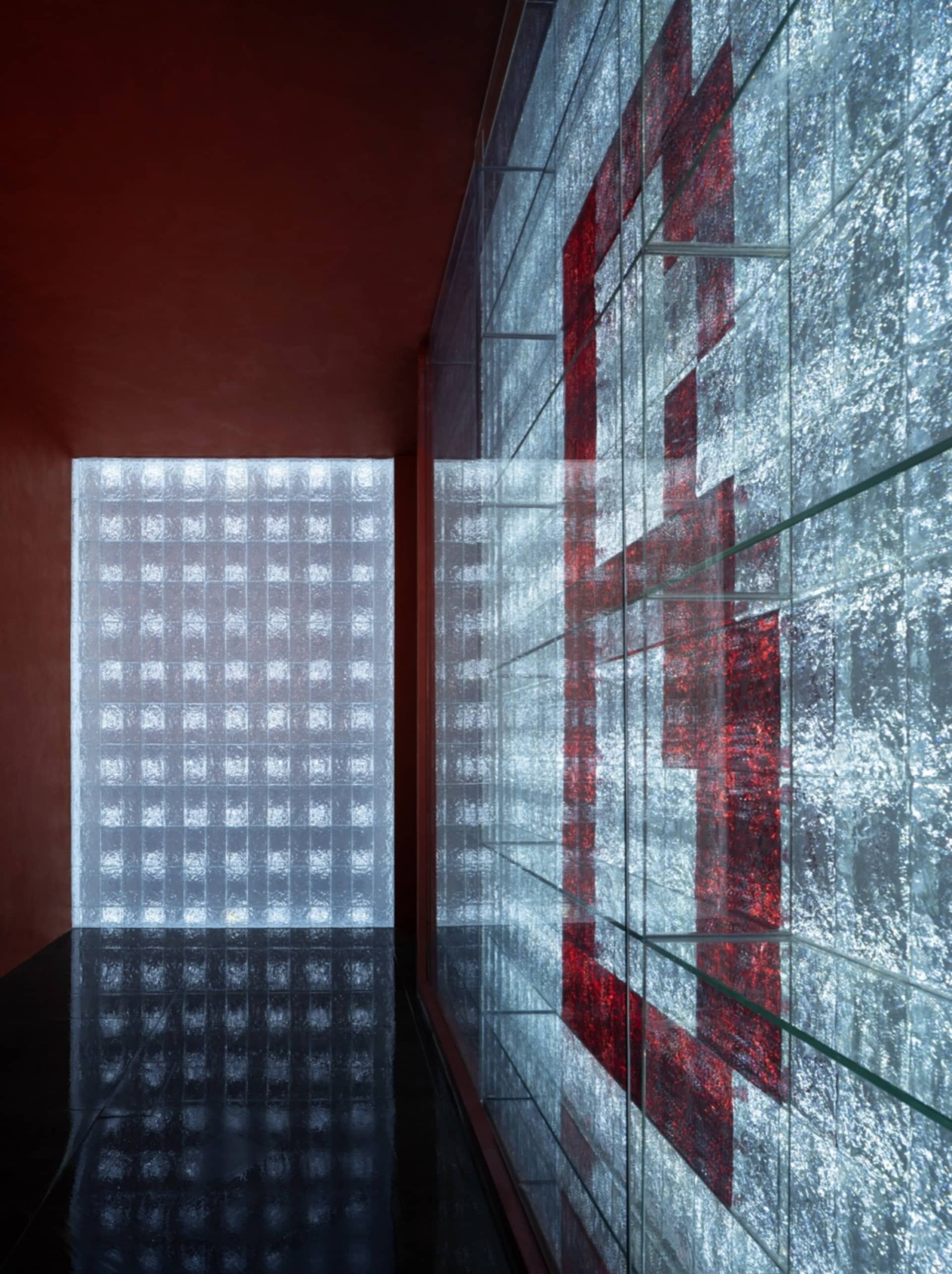 A modern interior design with a glass wall featuring red accents