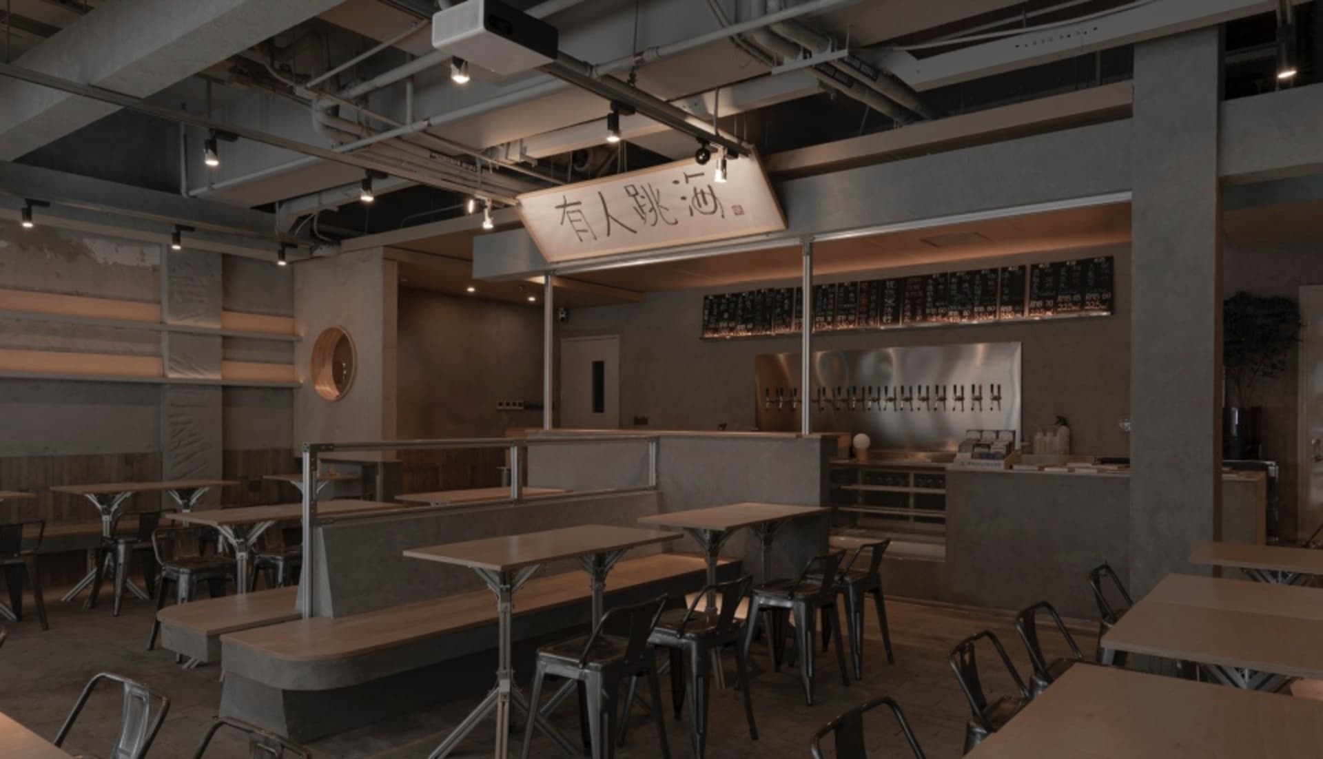 Modern, industrial-style restaurant interior with concrete walls and seating areas.