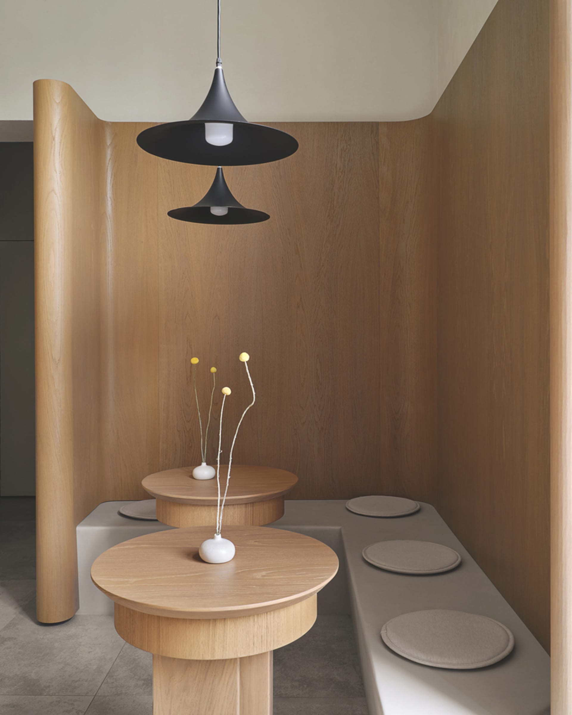 Modern designed restaurant booth seating with concrete flooring and wooden tables and benches.