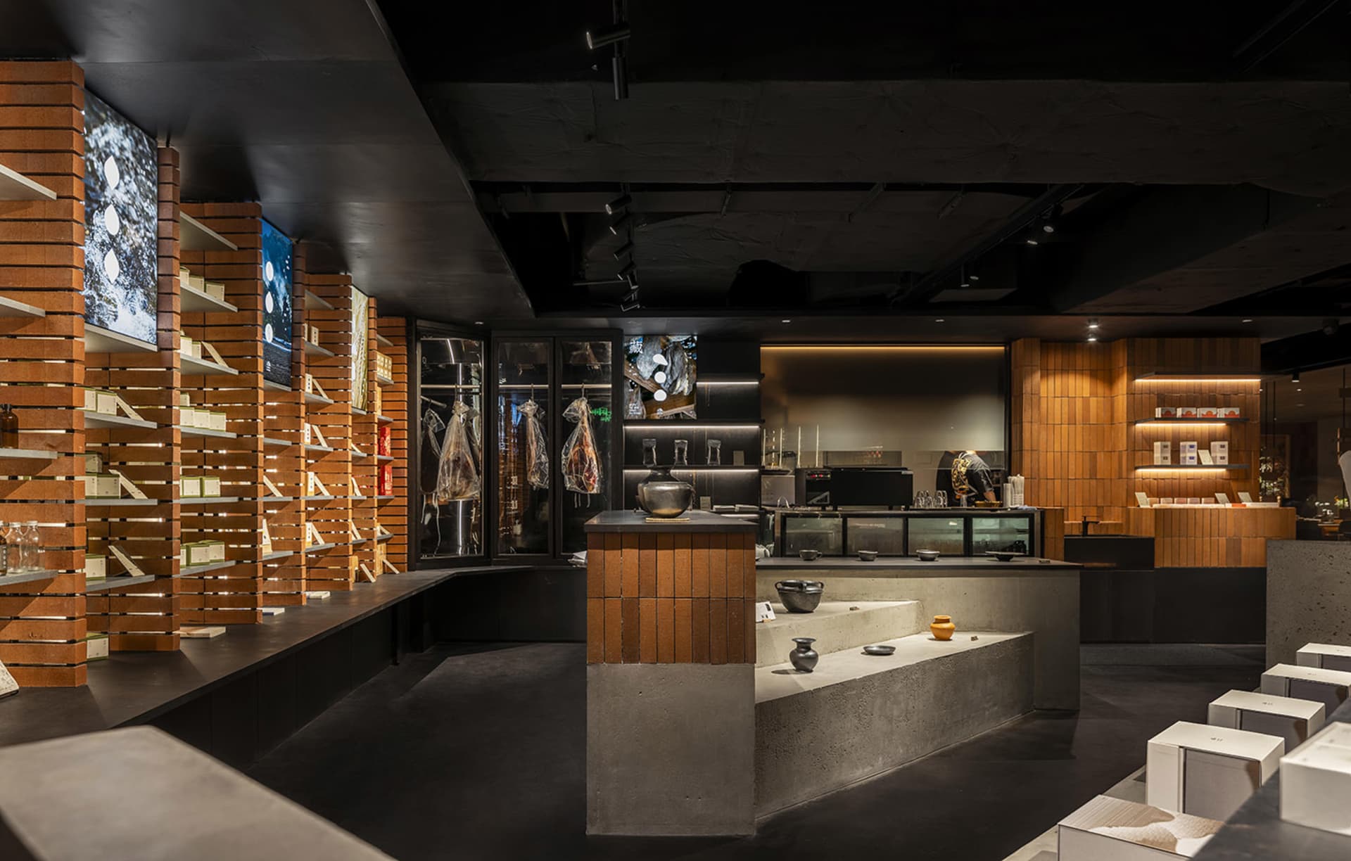 A modern coffee shop featuring exposed brick walls, concrete countertops, and wooden accents.
