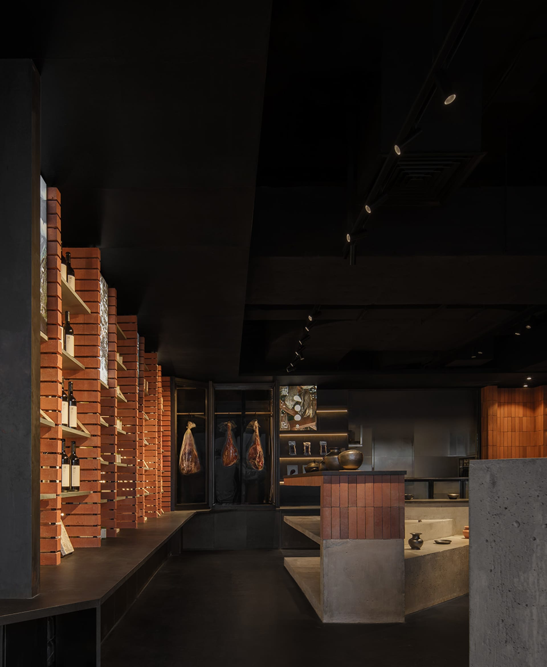 A modern industrial restaurant bar featuring exposed brick walls, concrete surfaces, and a mix of contemporary and rustic ele