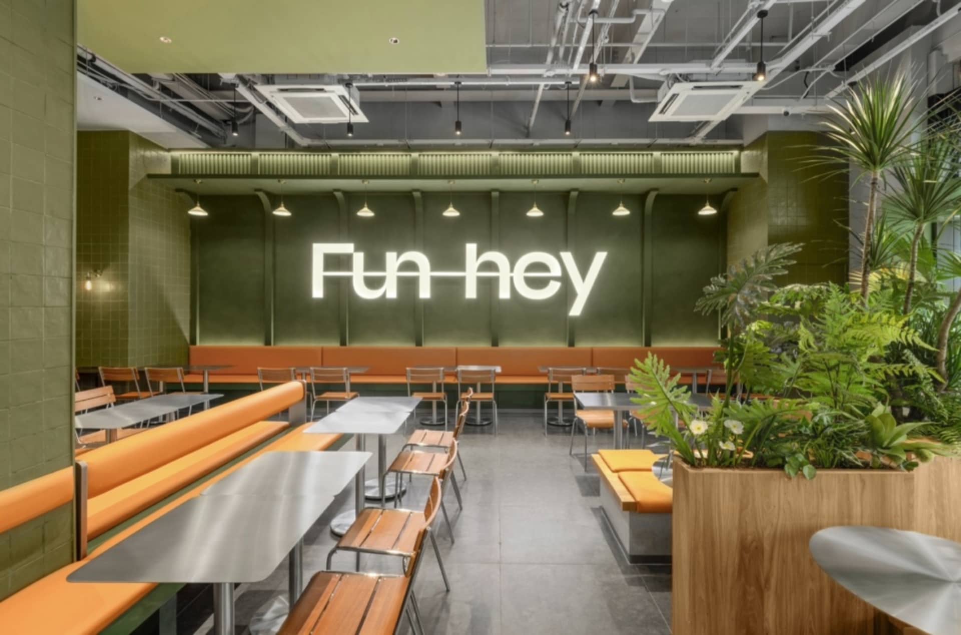 A modern, green-themed cafe with tile and concrete materials, featuring an industrial-style interior design.