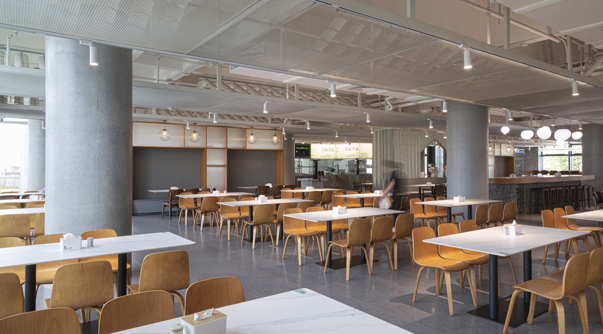 現代簡約風格餐廳室內，搭配混凝土與木質元素，並設有充足座位。