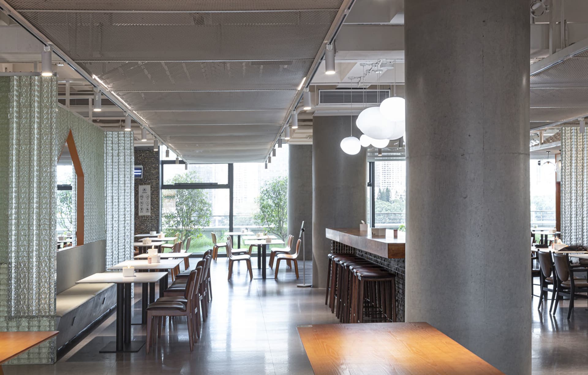 寬敞的現代工業風餐廳室內,採用混凝土、玻璃與木質材料。