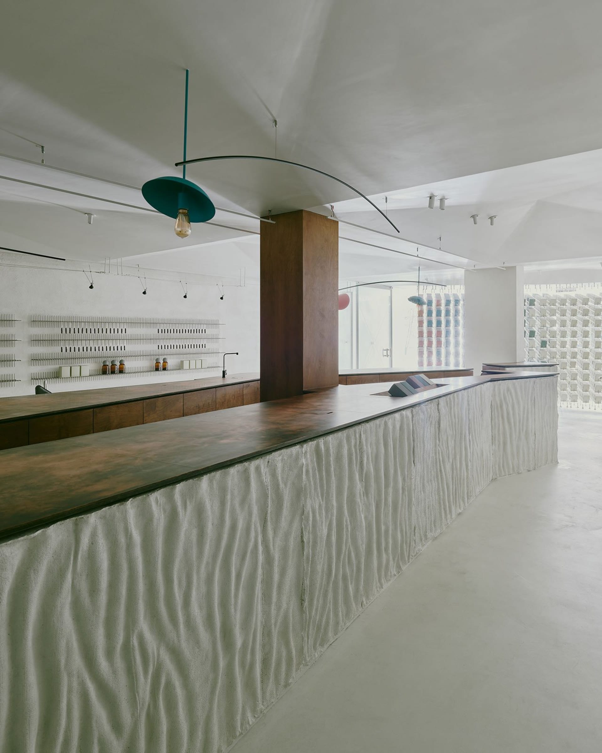 A minimalist restaurant with a white-tiled and concrete counter