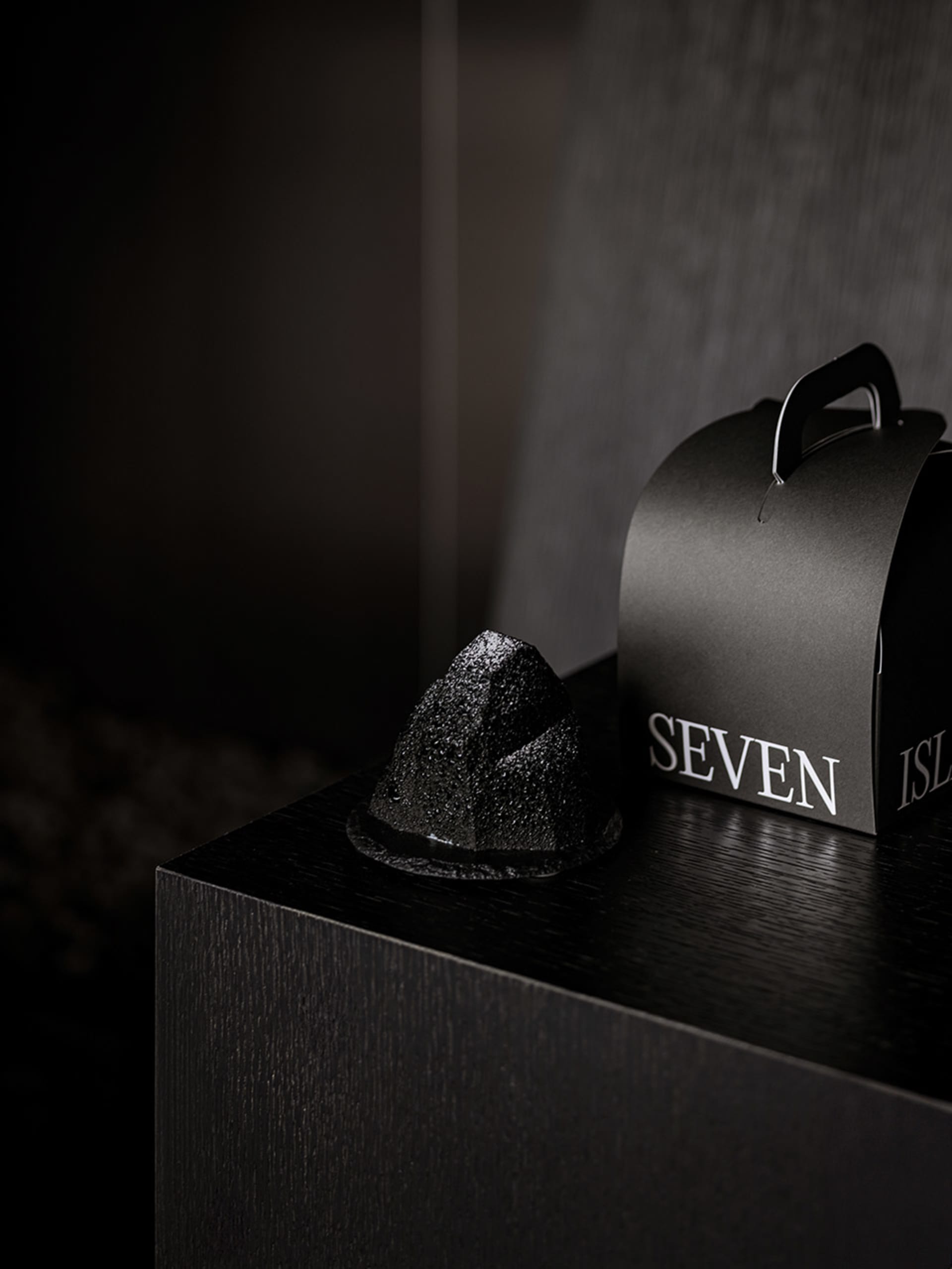 Black minimalist product packaging with 'SEVEN ISLANDS' text on a black surface.