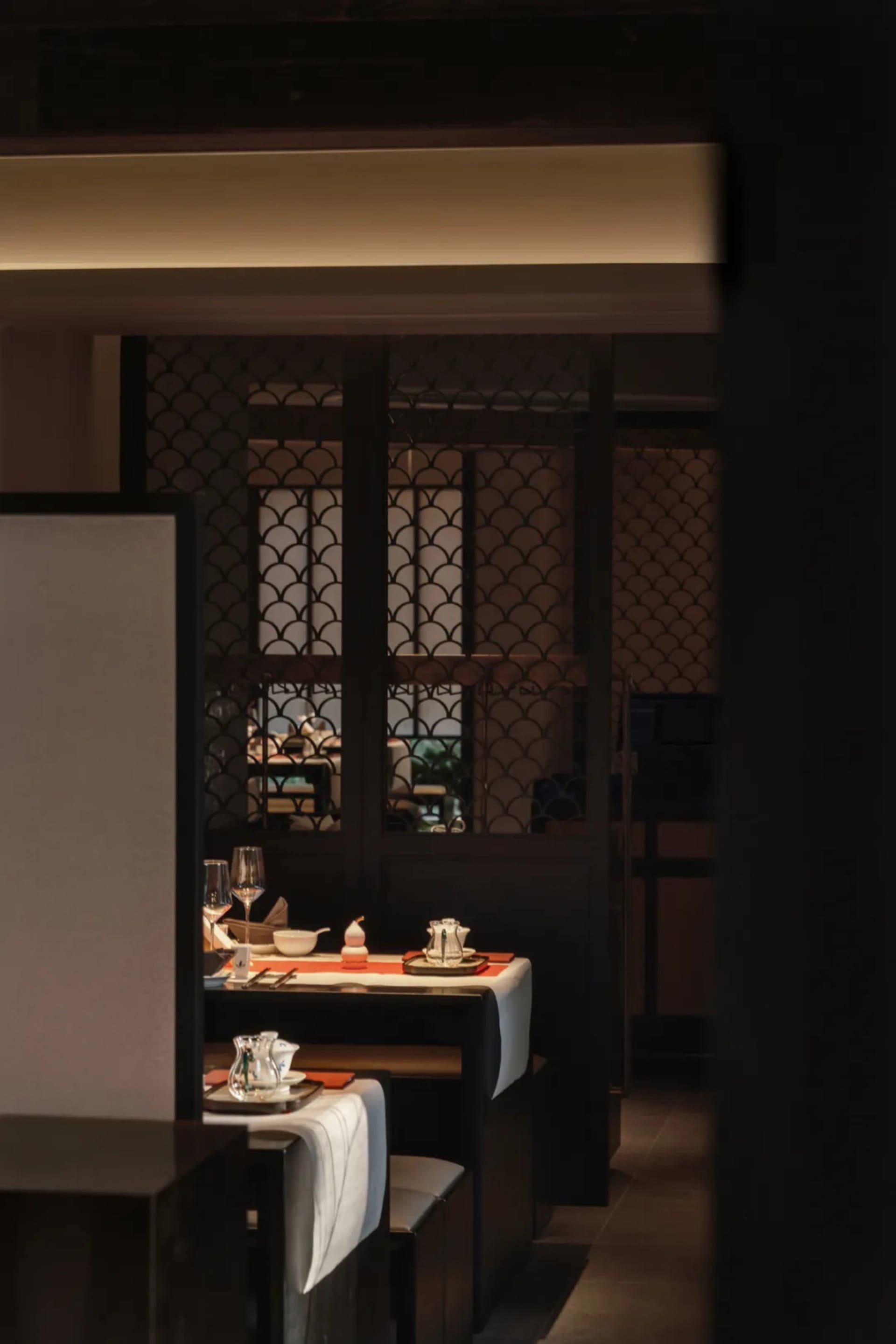 A traditional restaurant table setting featuring wooden furniture and elegant tableware.