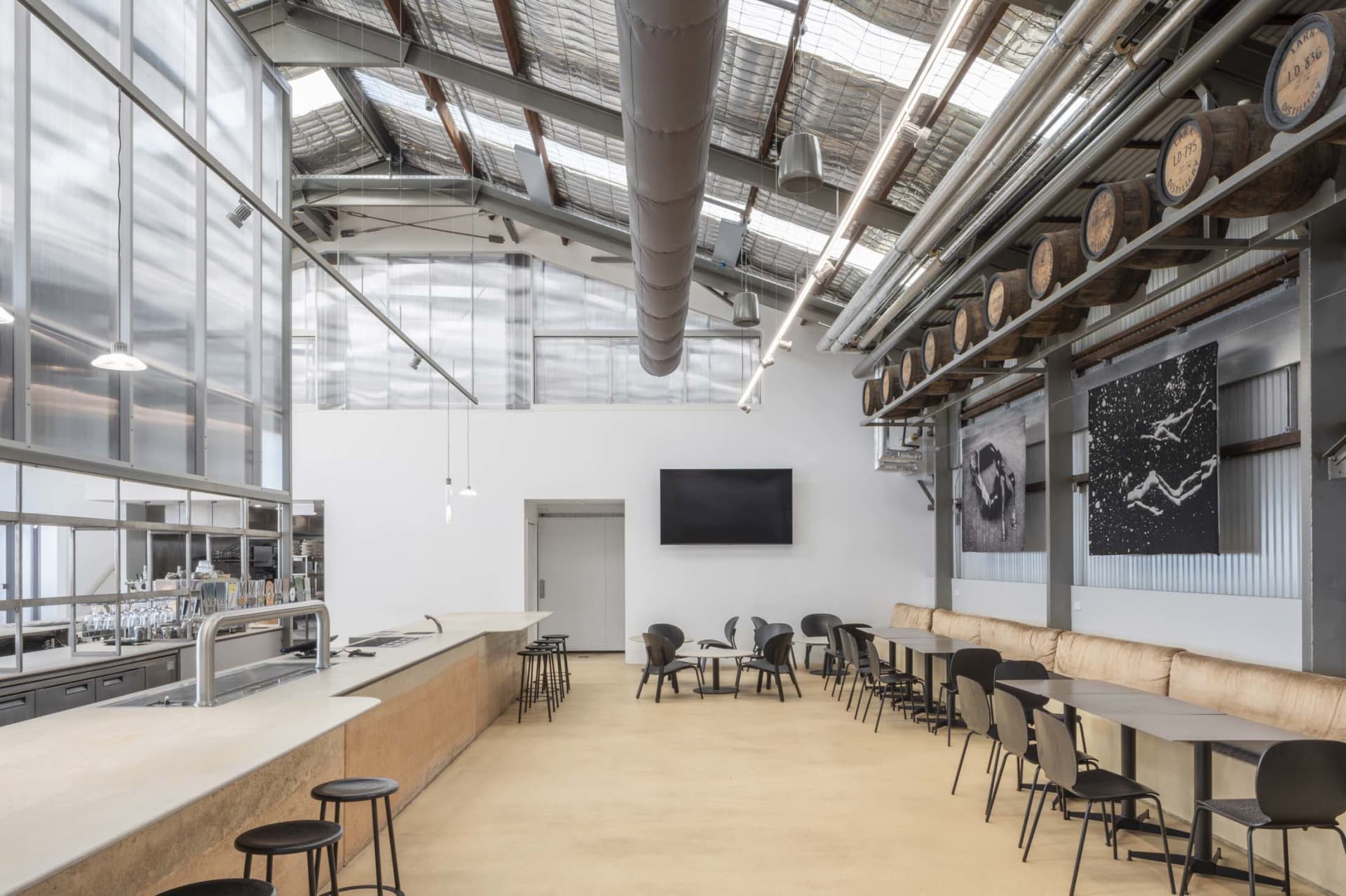 Industrial-style restaurant interior featuring concrete, metal, and glass materials.