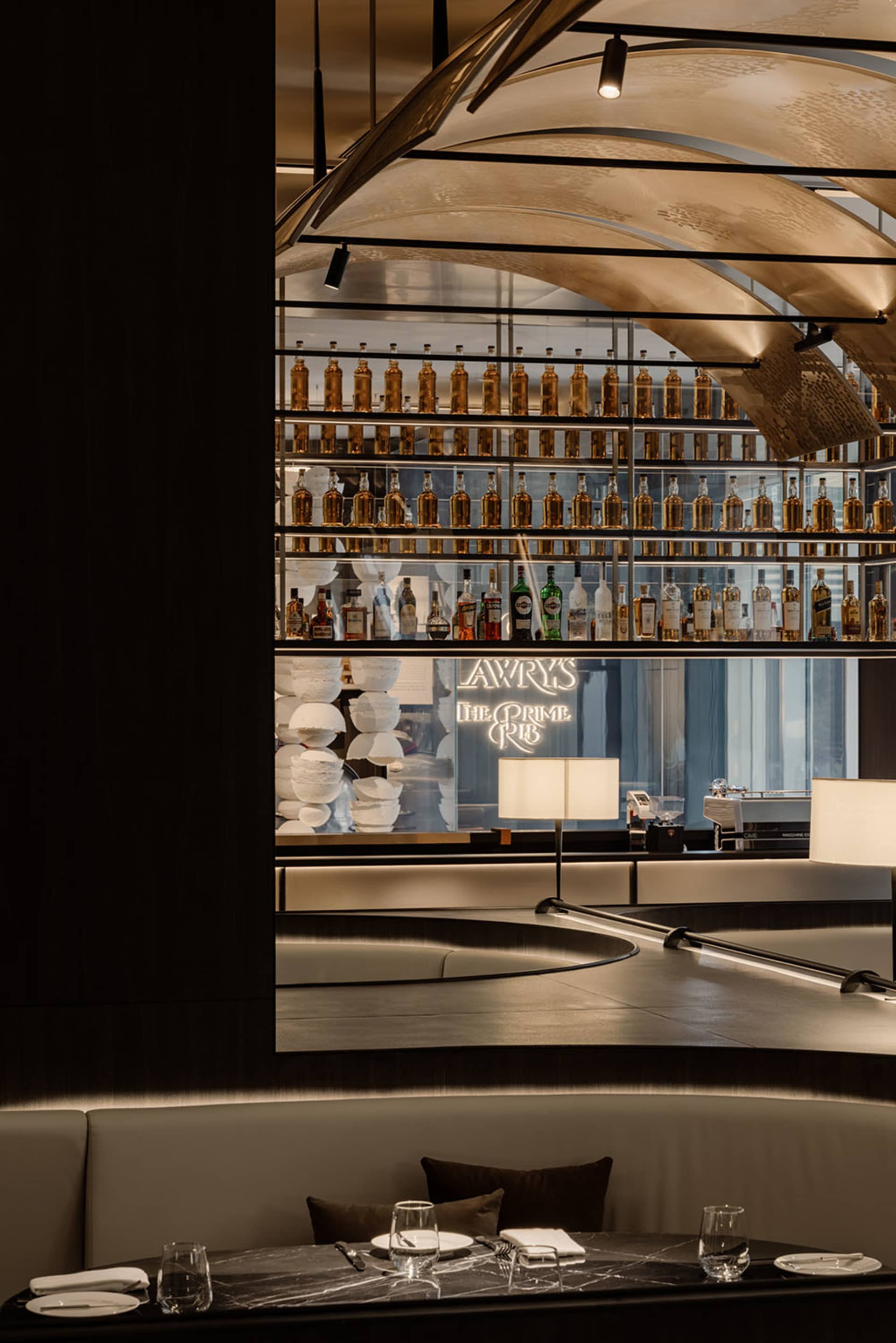 Industrial design restaurant interior with metal shelves, glass bottles, and marble tables.