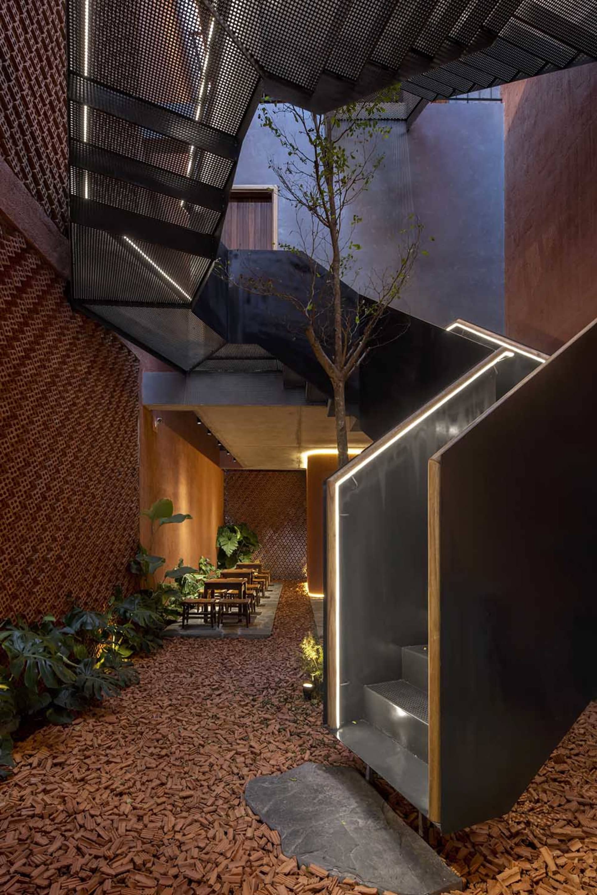 Modern interior features a metal staircase with greenery