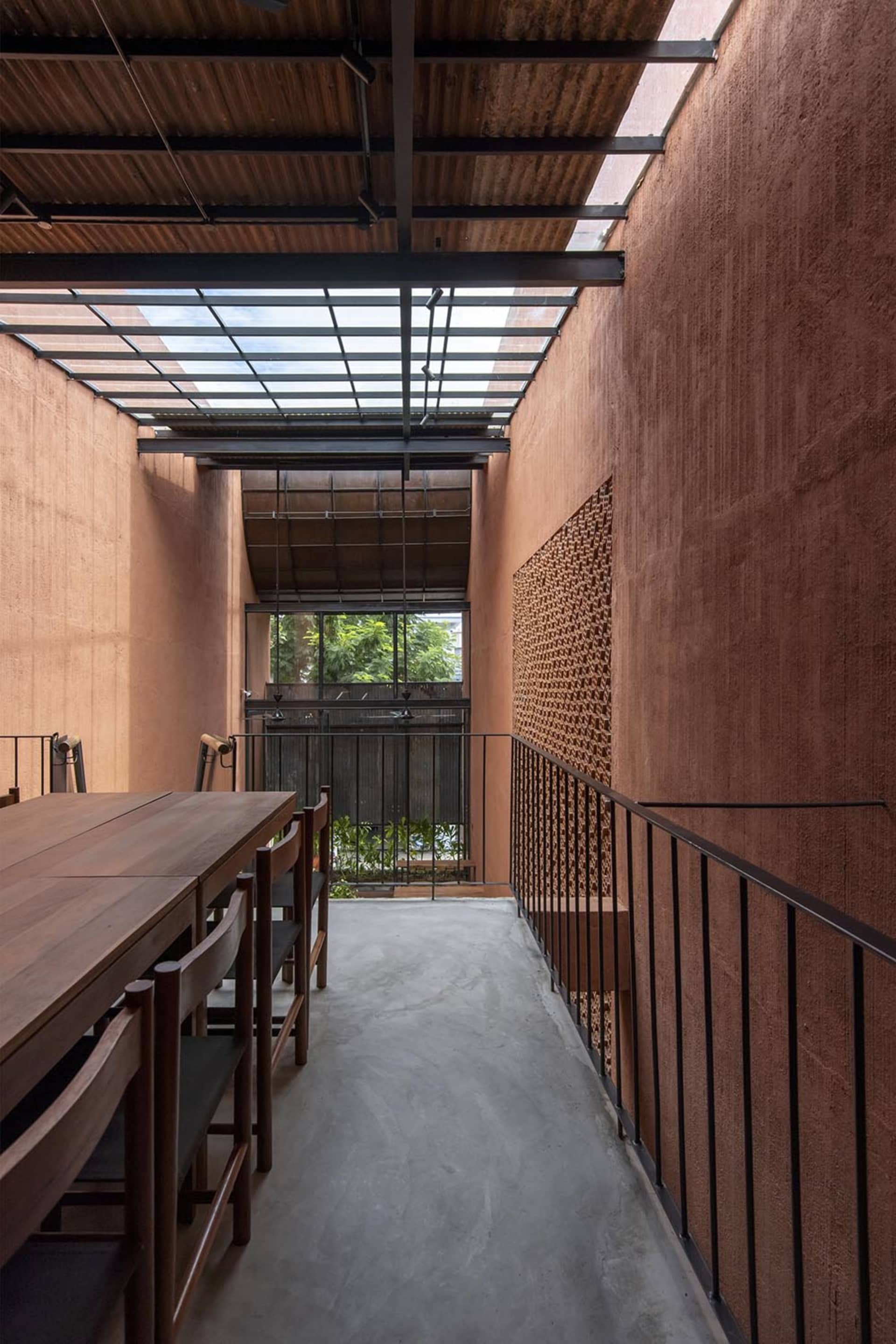 A minimalist architectural corridor featuring concrete materials in a glass-enclosed space.