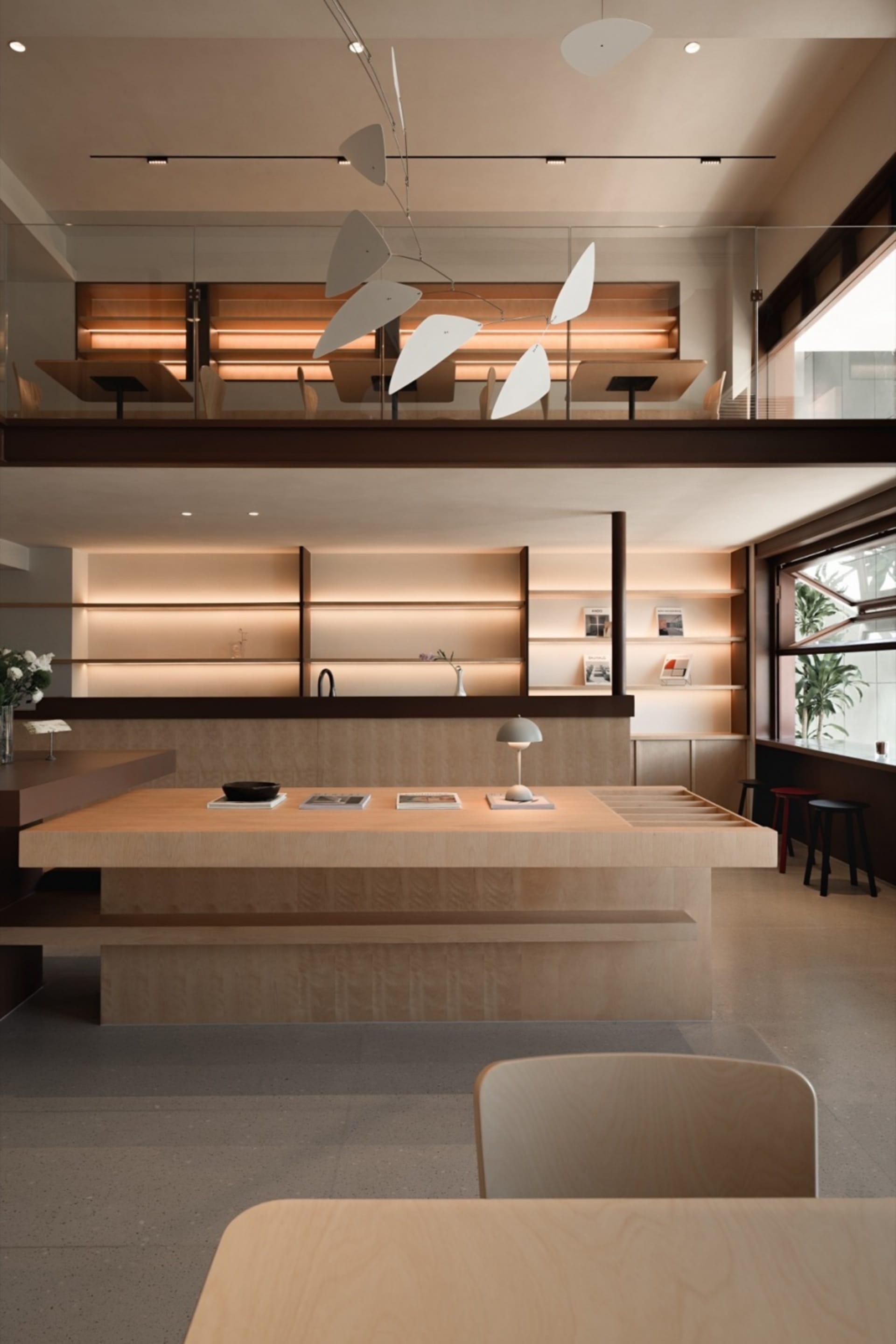 A minimalist coffee shop interior with wooden tables and glass walls.
