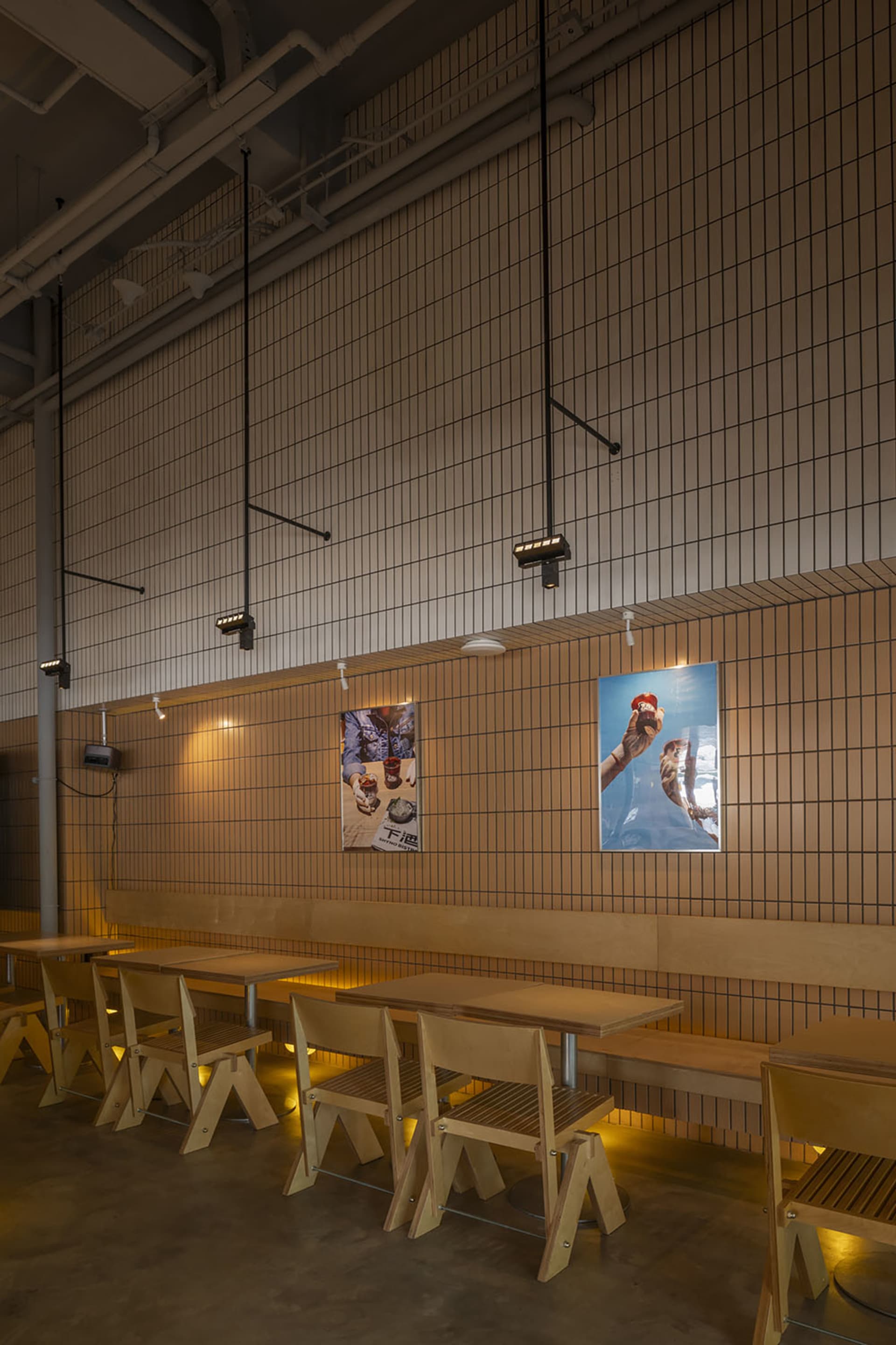 A modern restaurant interior with wooden furniture and a concrete floor.