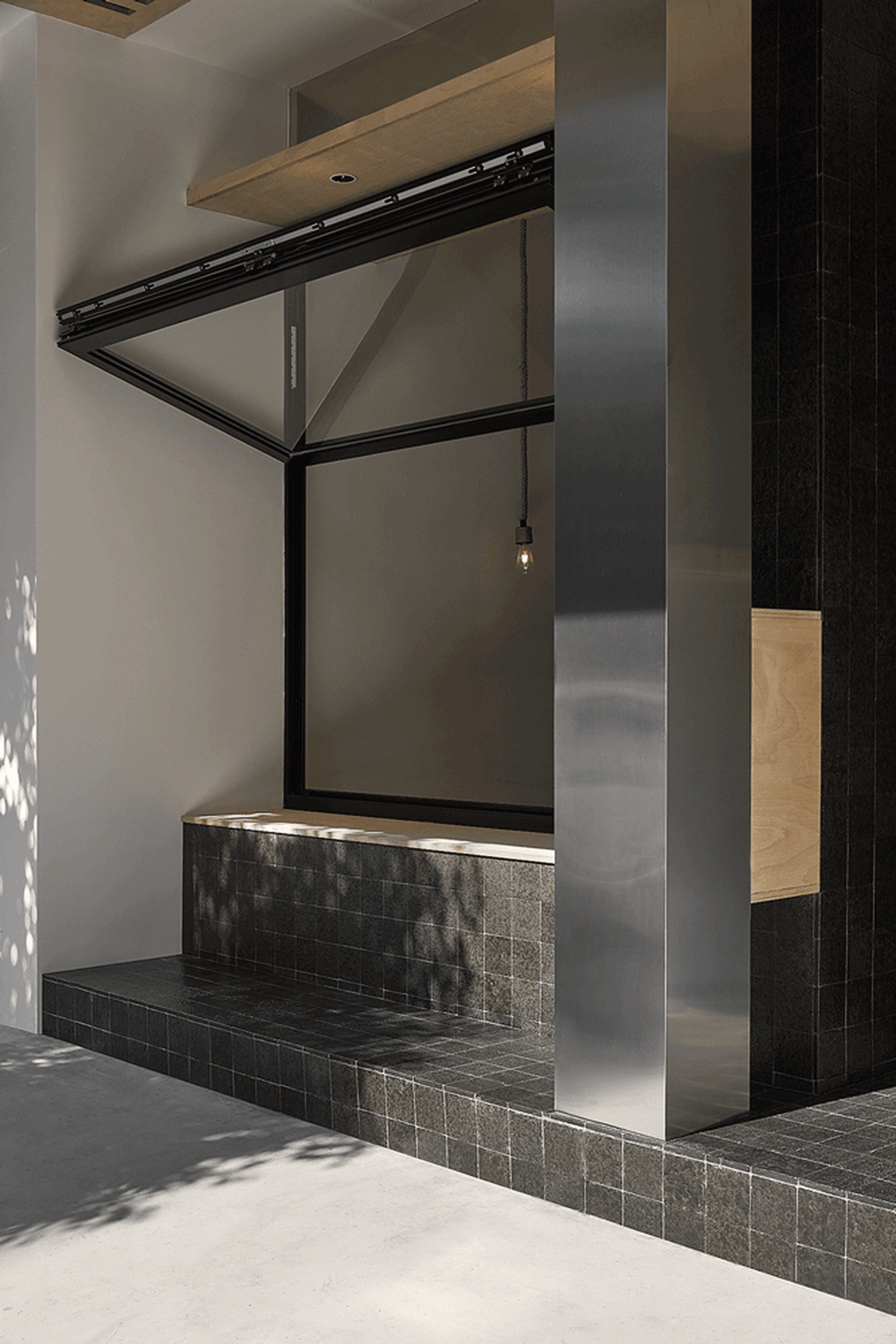 Modern interior space featuring concrete and tiled flooring with metal accents.