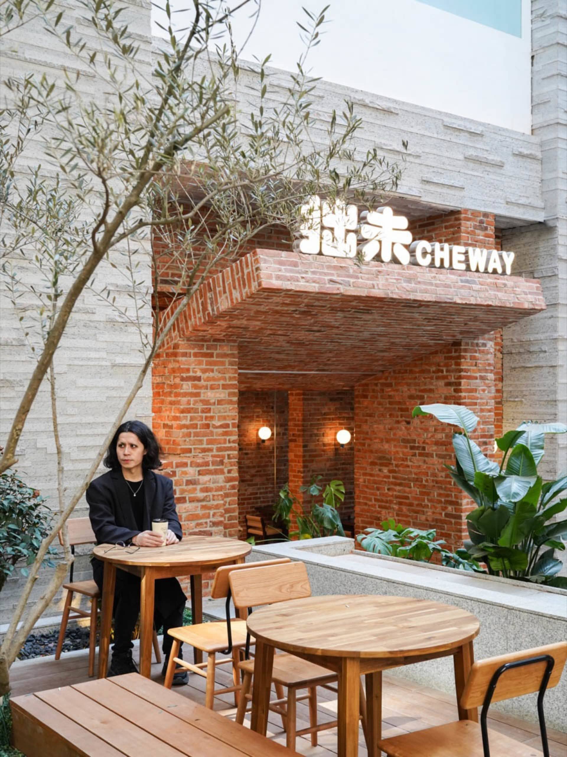Industrial-style restaurant exterior with brick walls and white signage