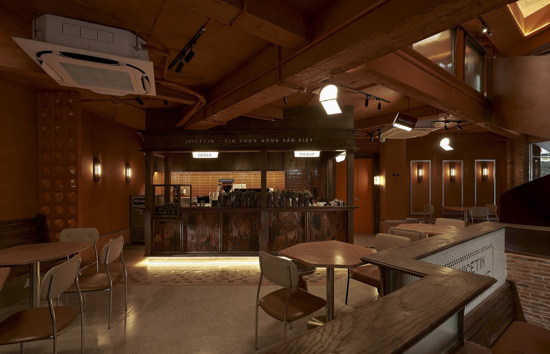 Interior of an industrial-themed restaurant with wooden tables and chairs.