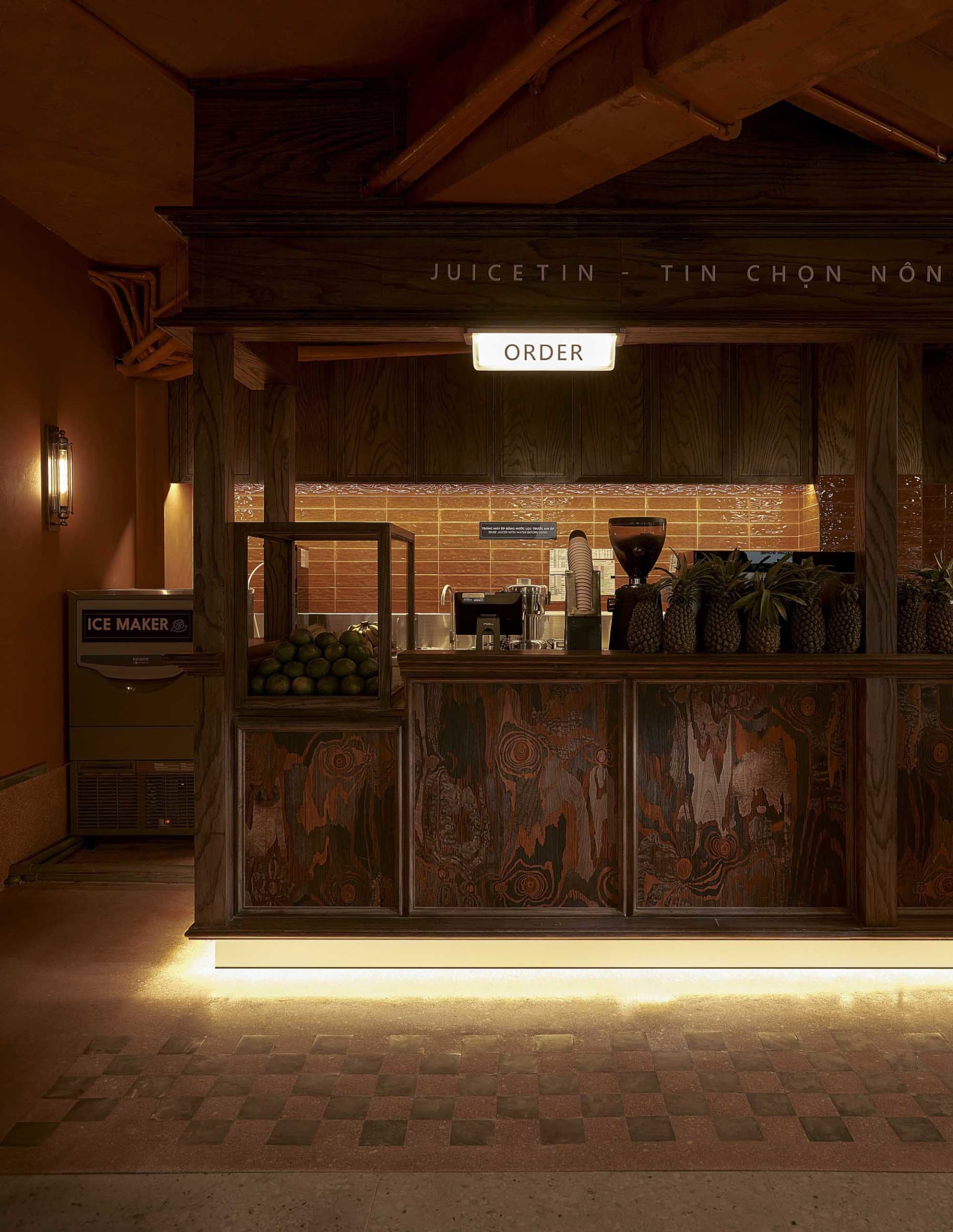 A modern coffee shop counter made of wood with a sign that says 'ORDER'.