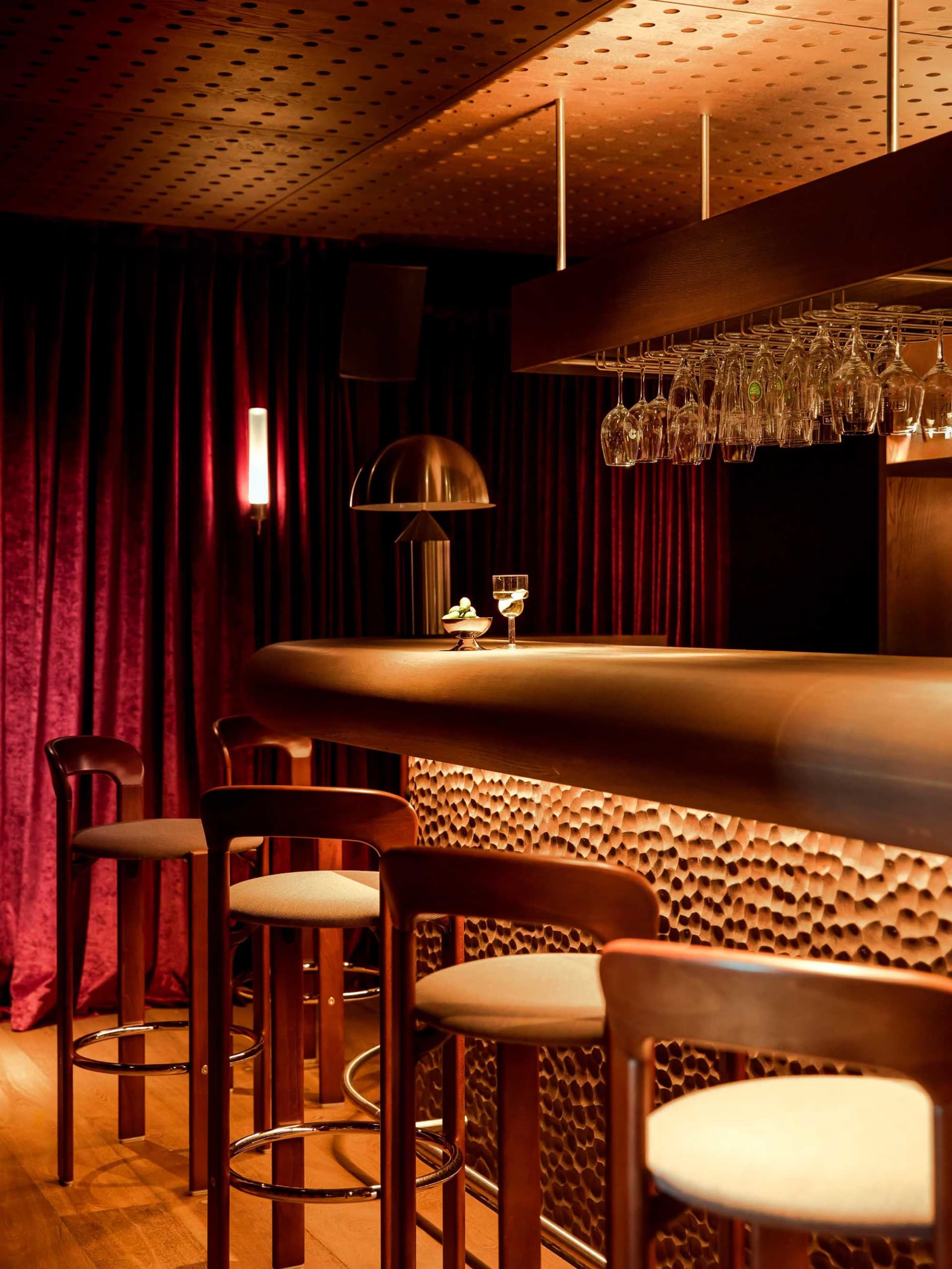 現代餐廳吧台,木質吧檯搭配發光吧椅與懸掛酒杯。