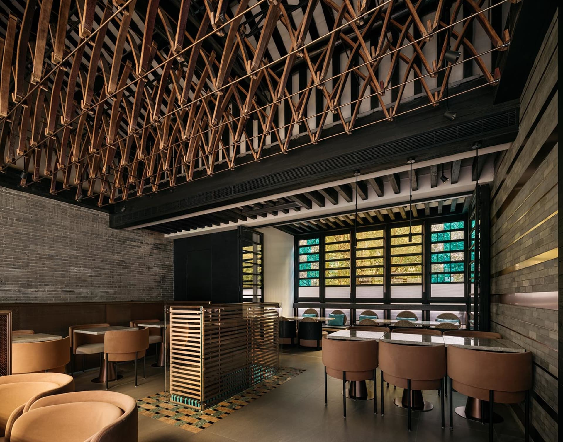 An industrial-themed restaurant interior with wooden structures and concrete walls, featuring glass elements for lighting and