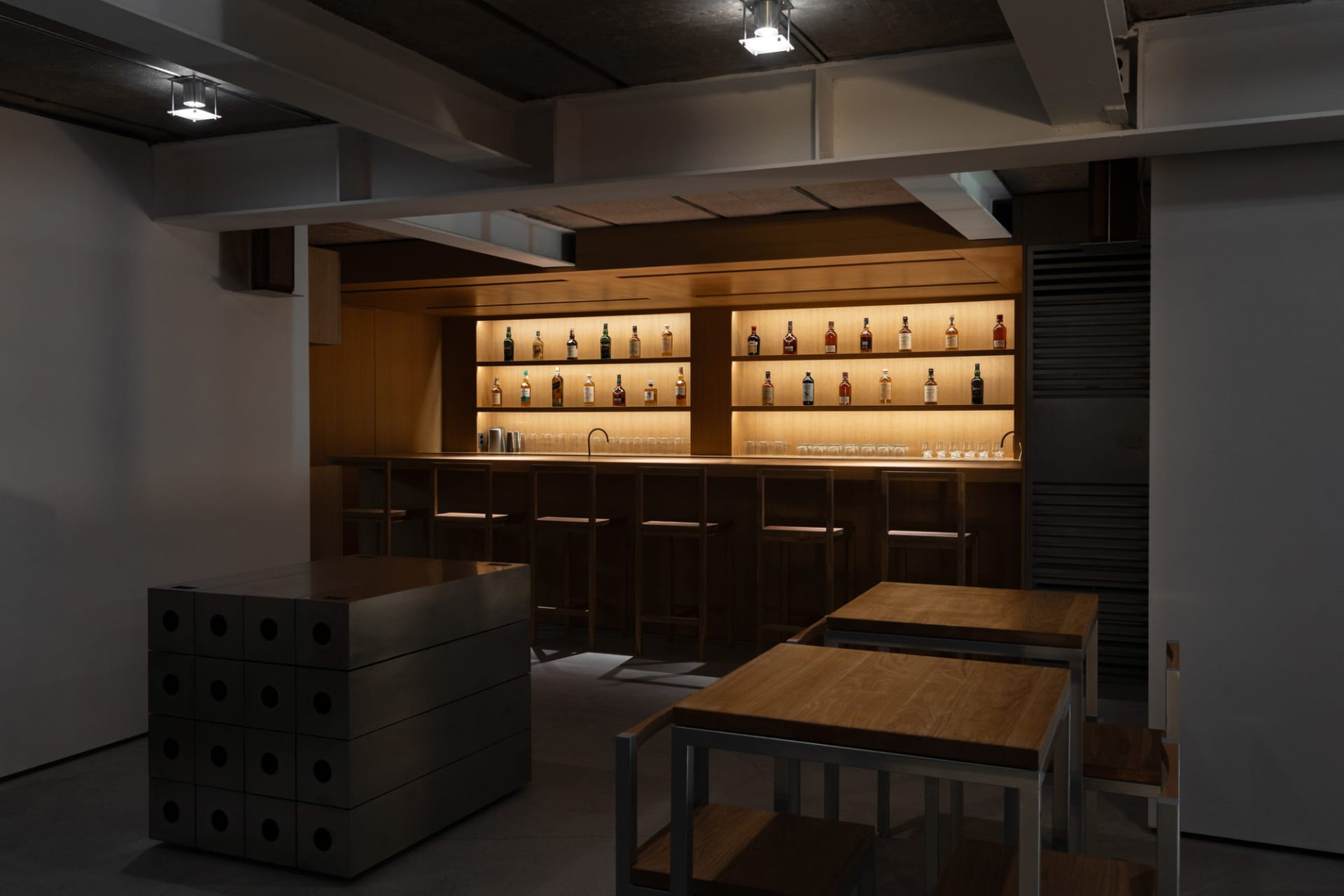 現代吧台採用木質檯面,搭配發光層架展示各式酒瓶。