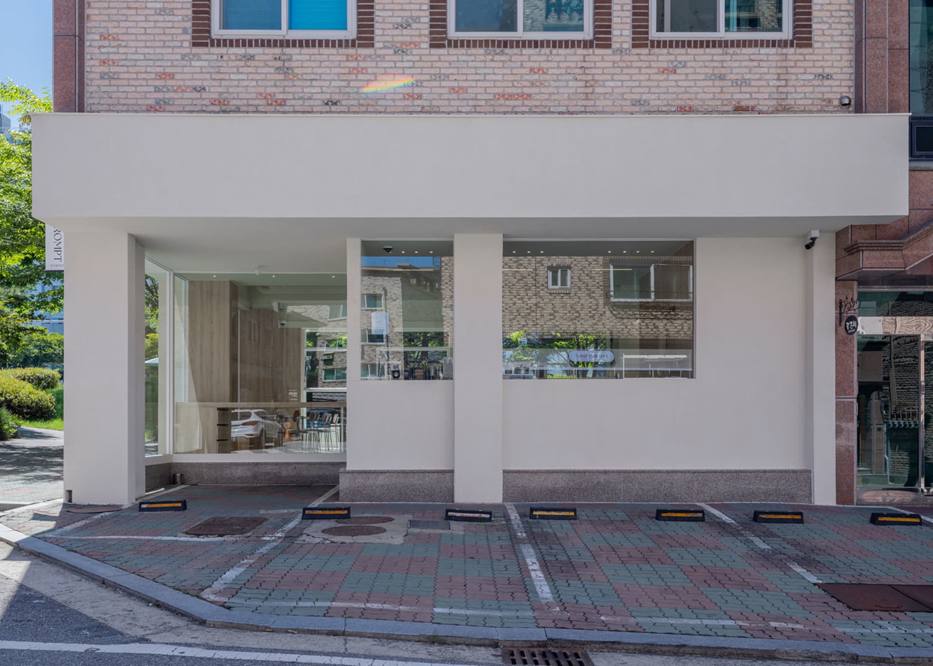 A modern coffee shop exterior with glass and concrete materials.