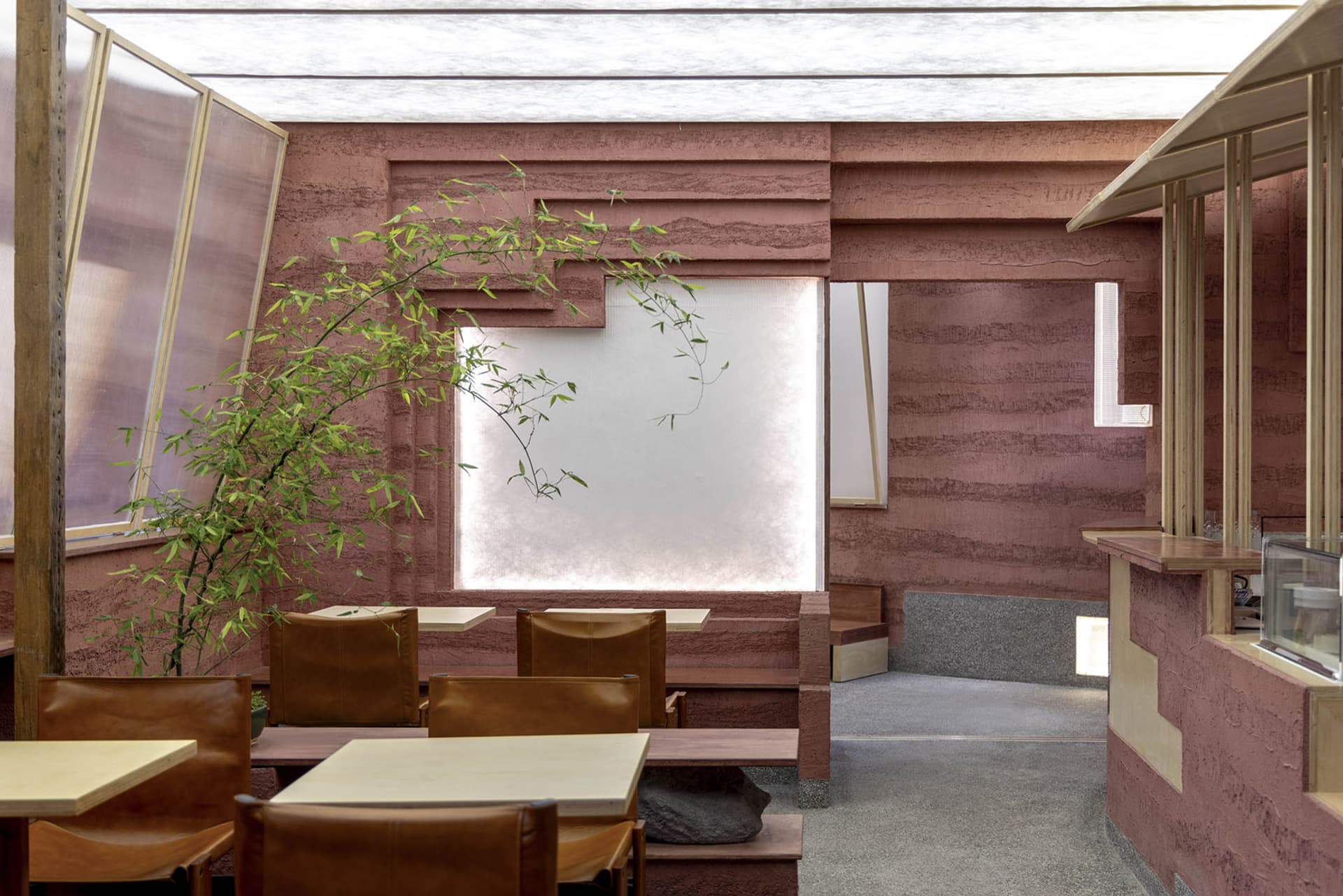 Modern restaurant interior with concrete walls and leather seating