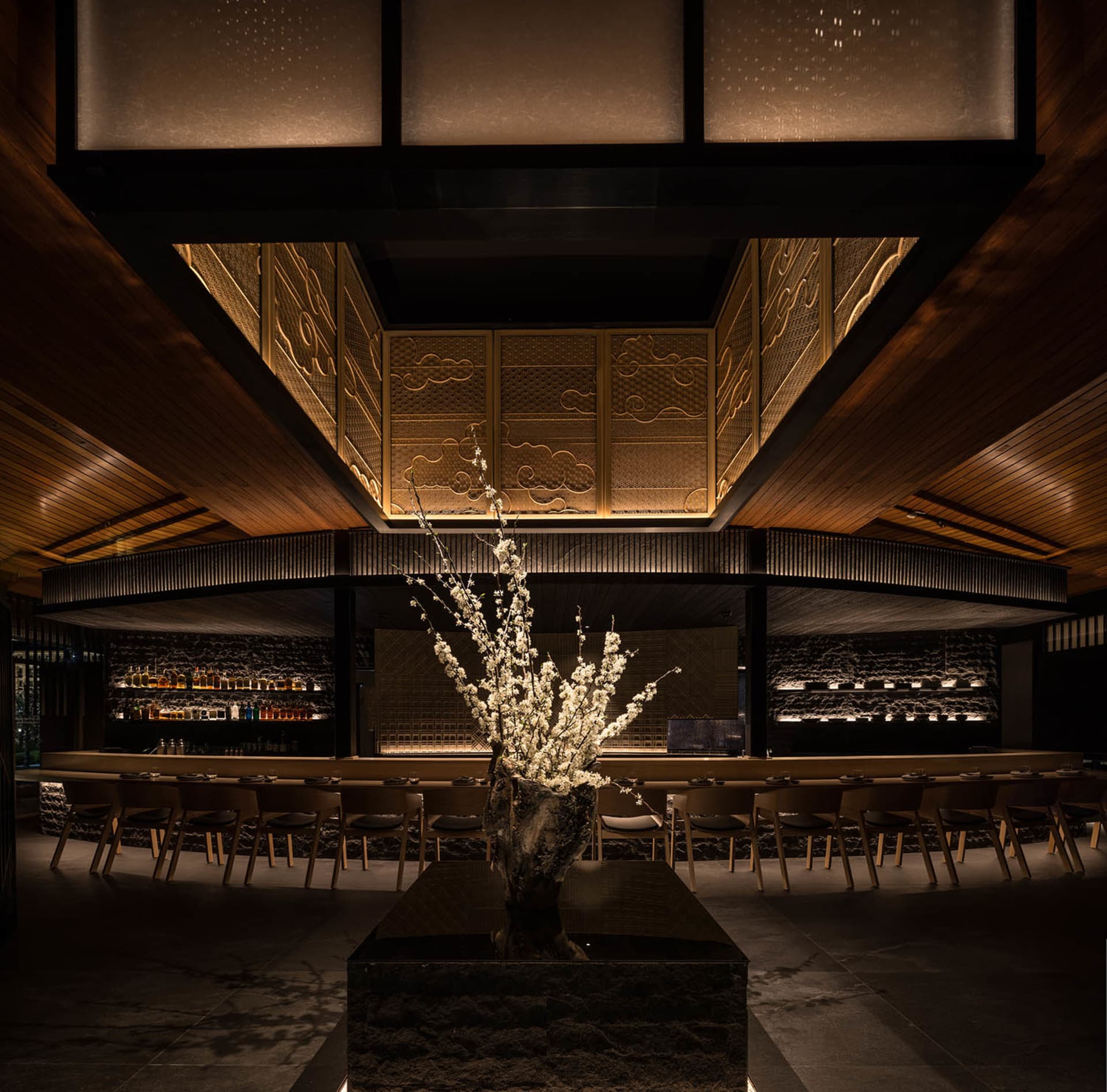 A modern restaurant interior featuring wooden decor and lighting.