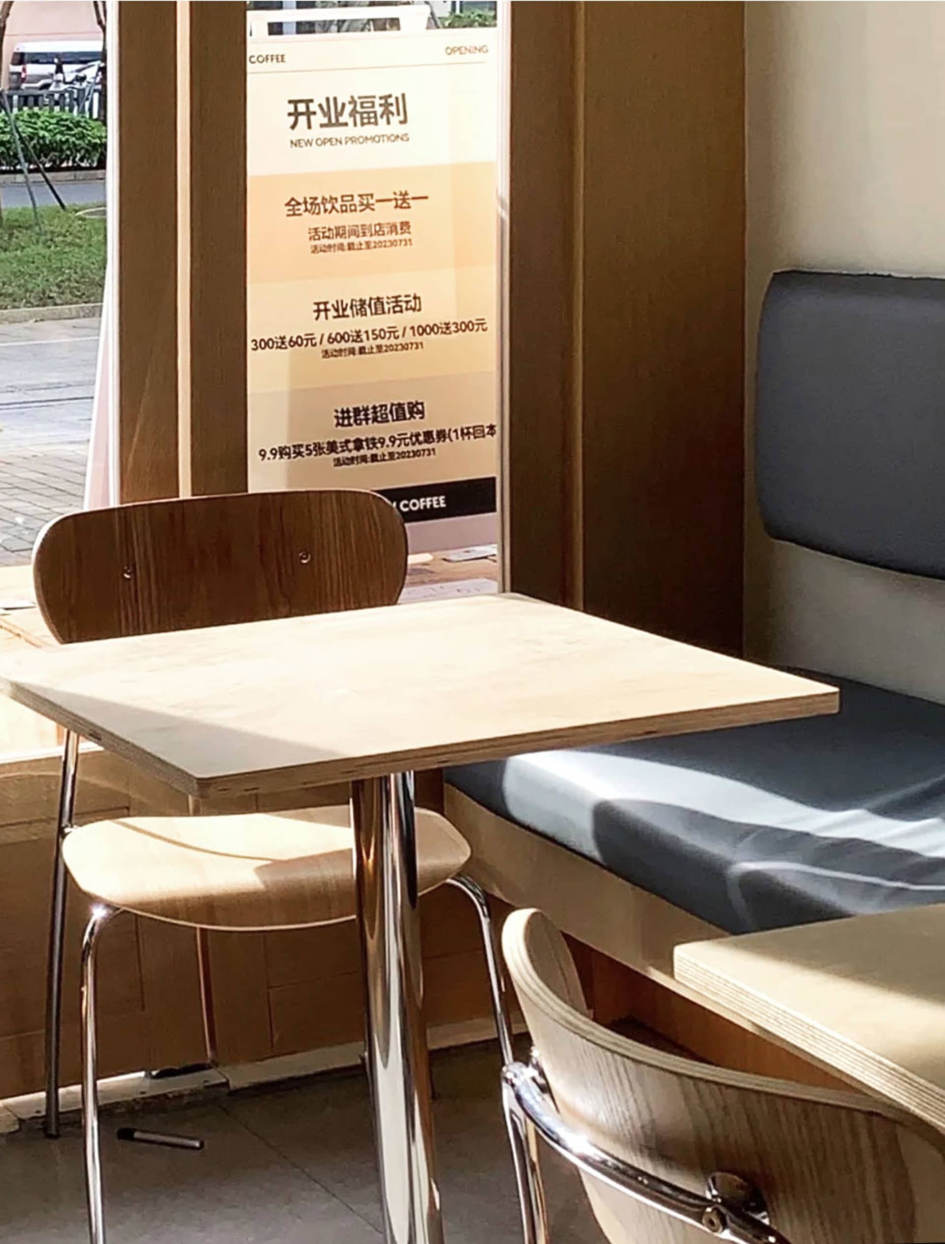 咖啡廳室內擺放木質家具,並有宣傳海報