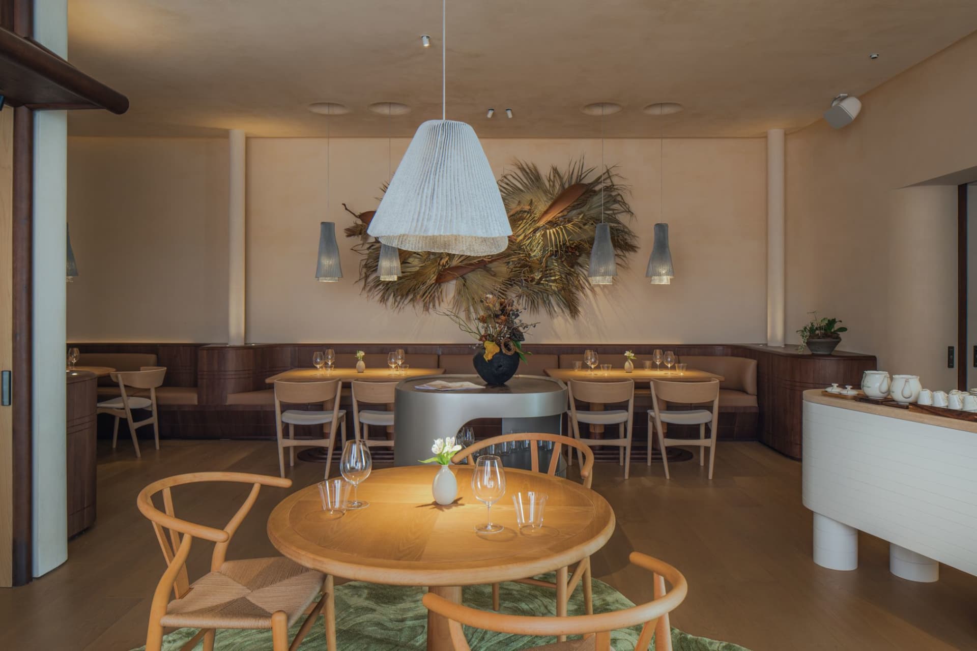 溫馨的餐廳用餐區，採用現代設計，搭配木質餐桌、布面吊燈與綠色植栽。