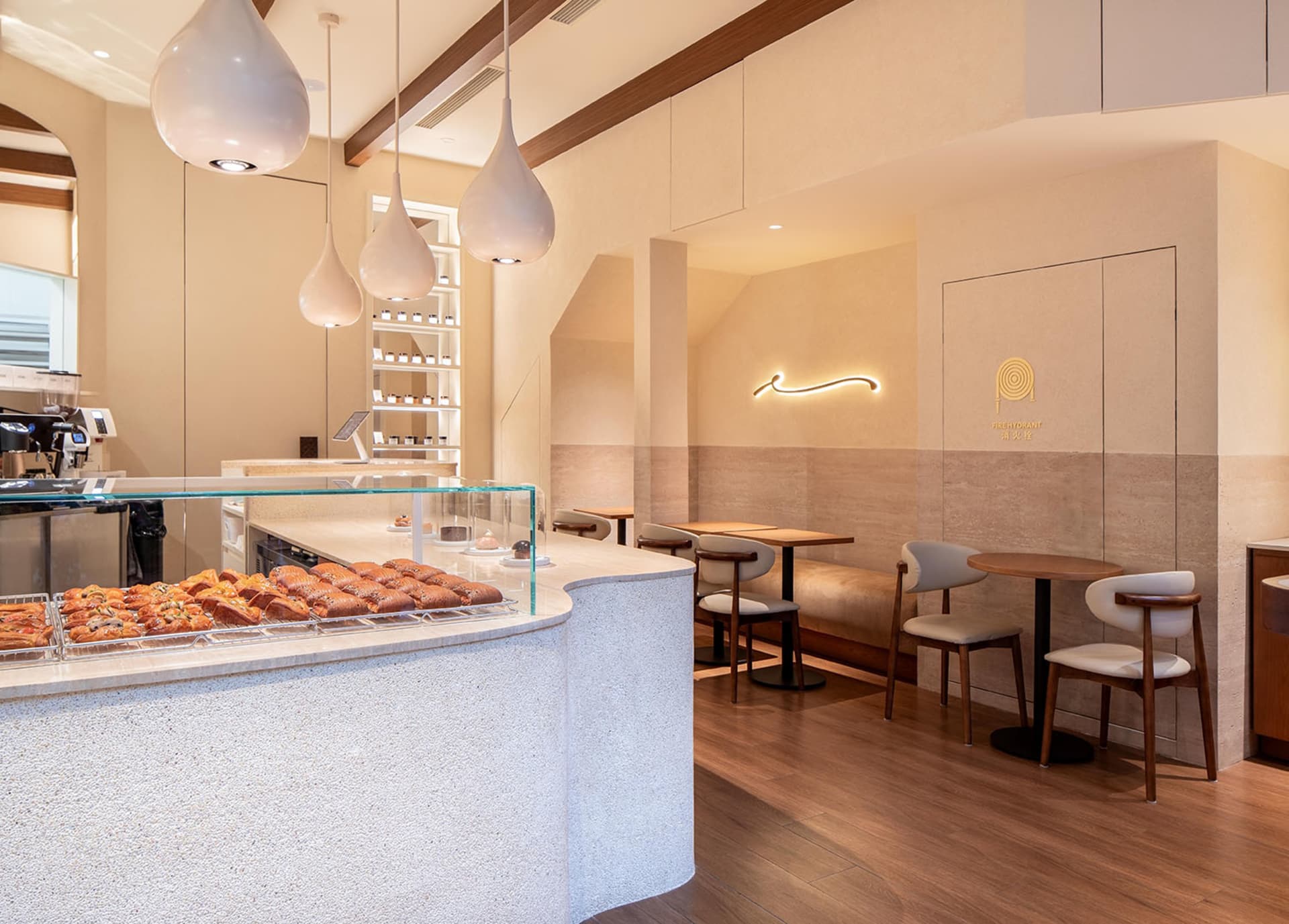 Modern coffee shop with neutral color scheme and wooden flooring.