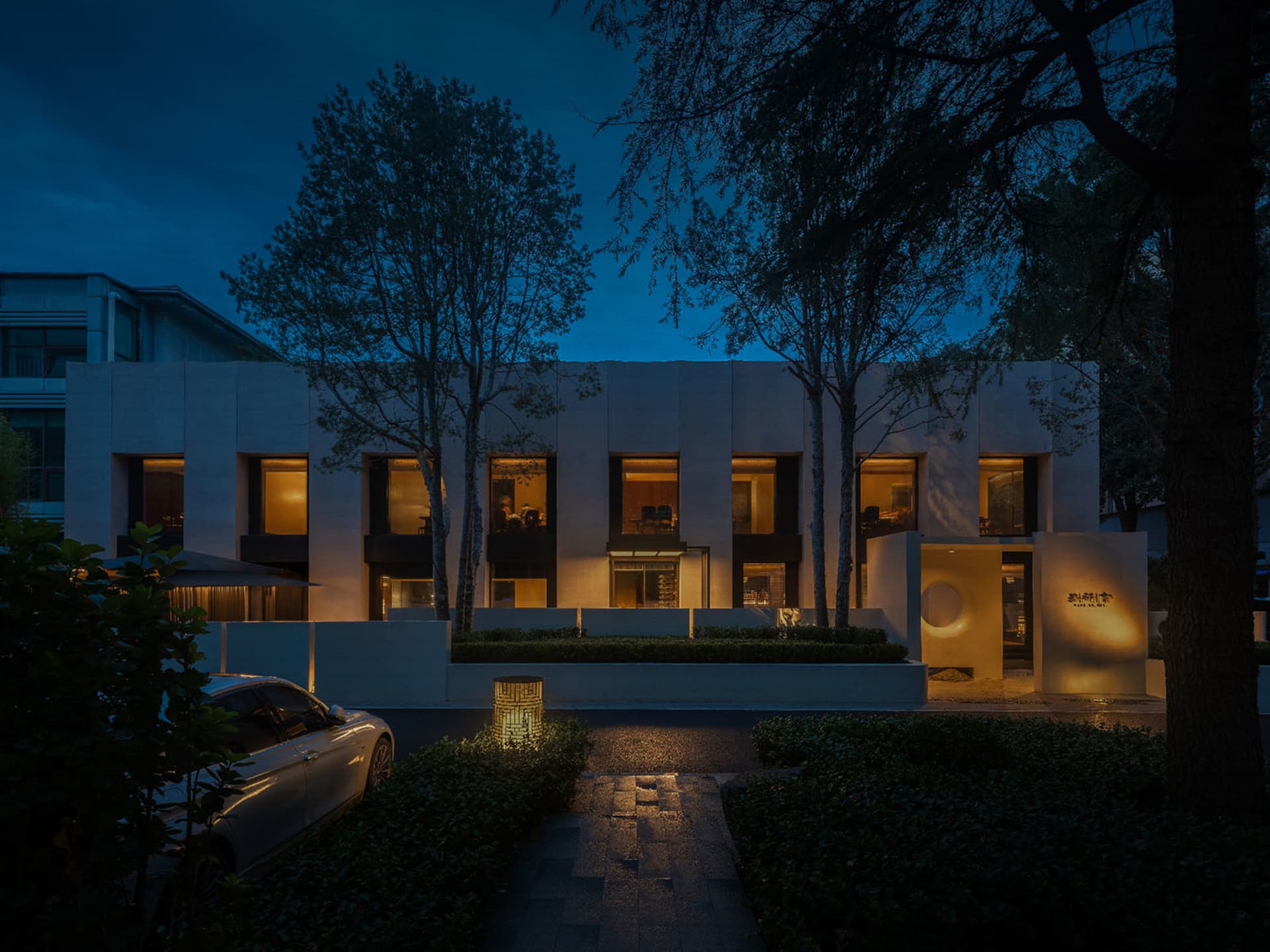 A modern building with a minimalist design featuring large windows and a clean, white exterior.