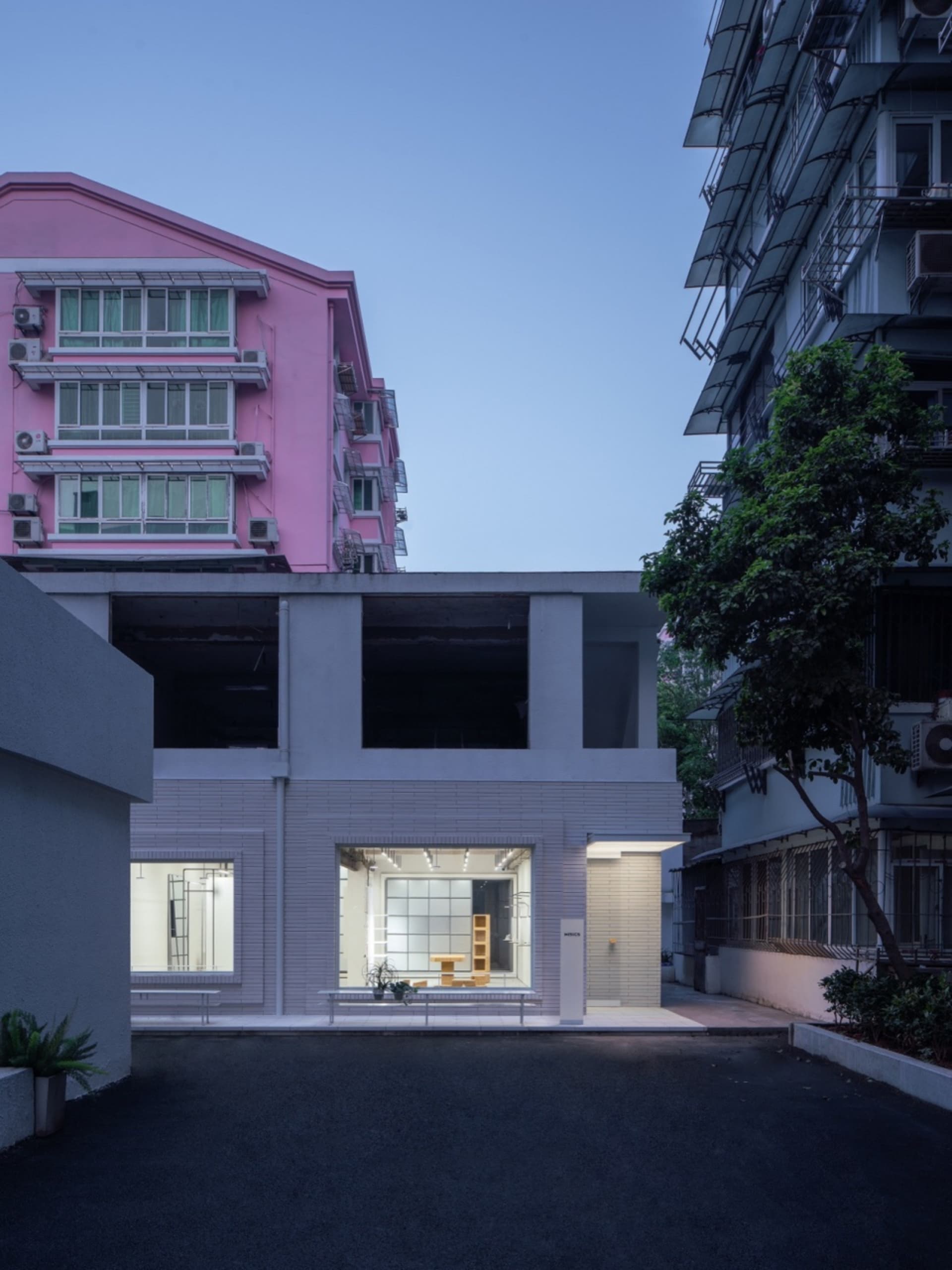 A modern commercial building featuring concrete structural elements and large glass windows.