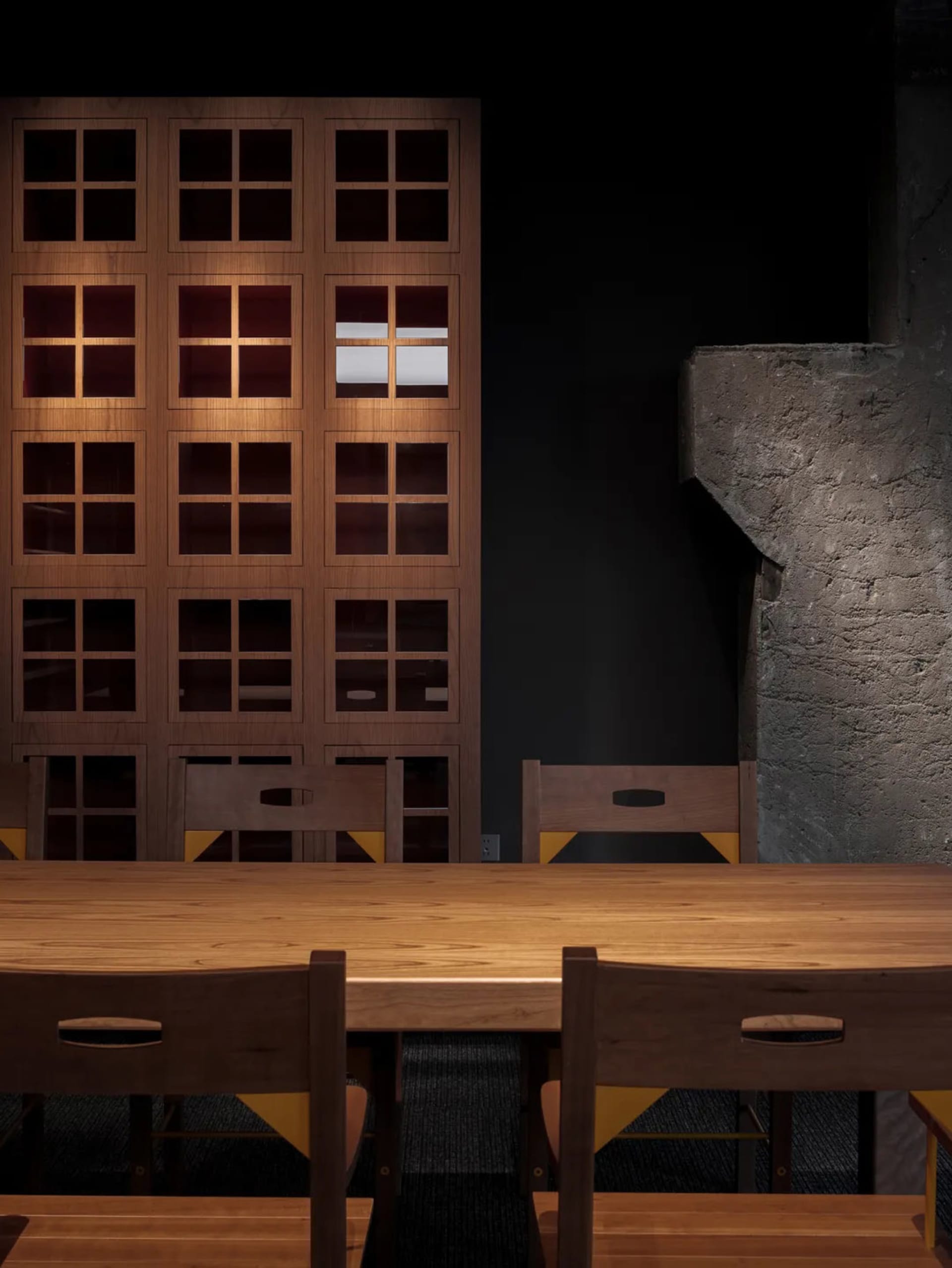 Industrial-style restaurant interior with wooden furniture and a large, illuminated cabinet.
