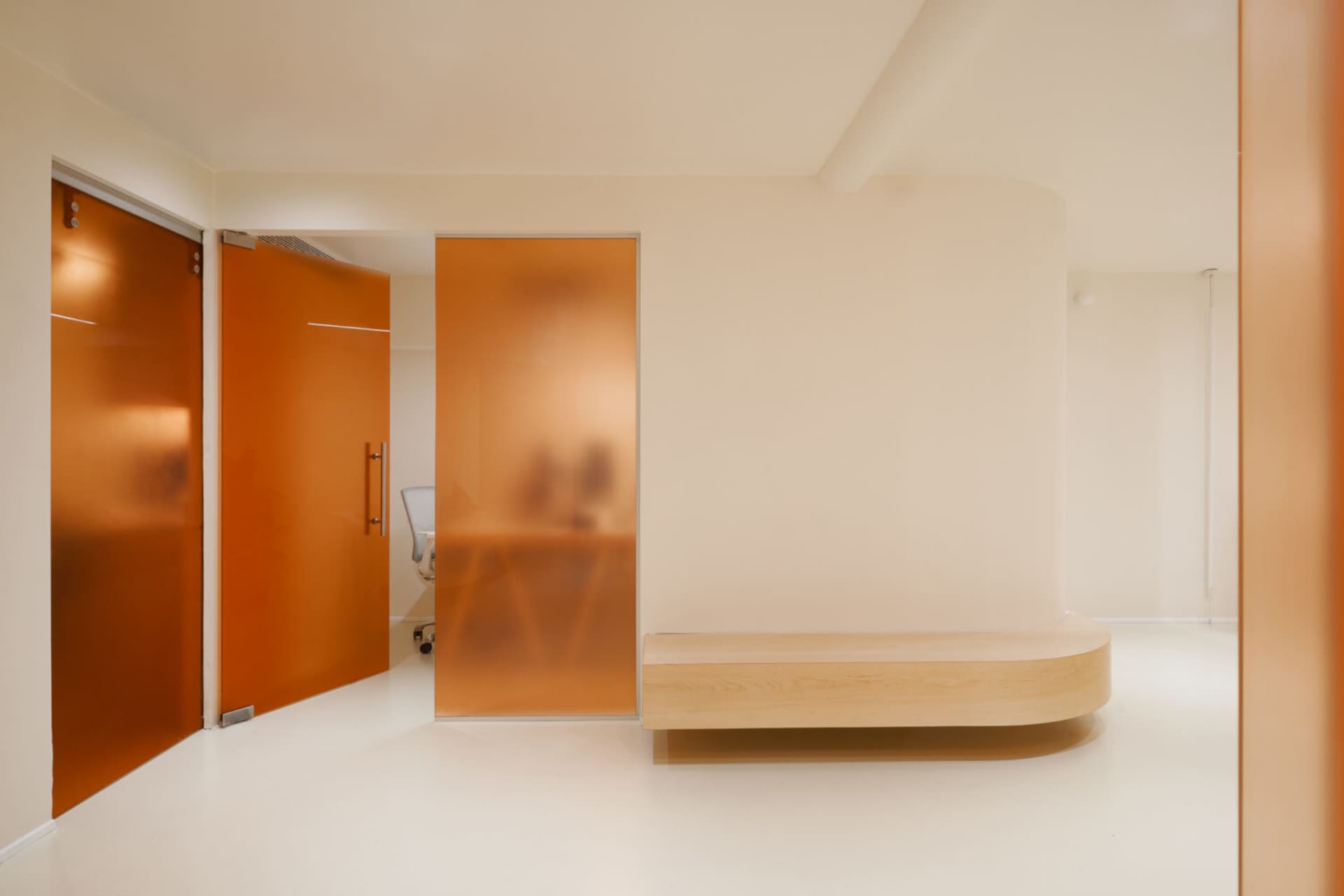 An interior design photograph showcasing modern hospitality features, including glass walls and minimalist furniture.