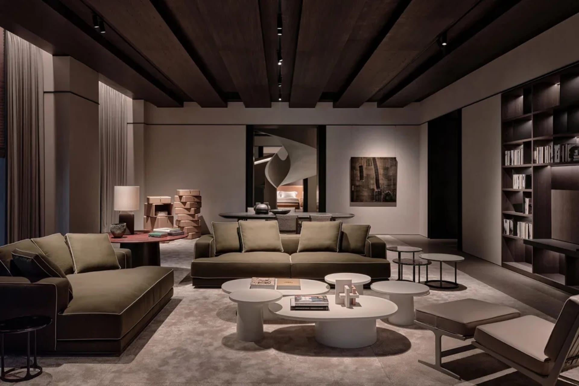 A spacious modern living room featuring two plush green sofas and several white round coffee tables.