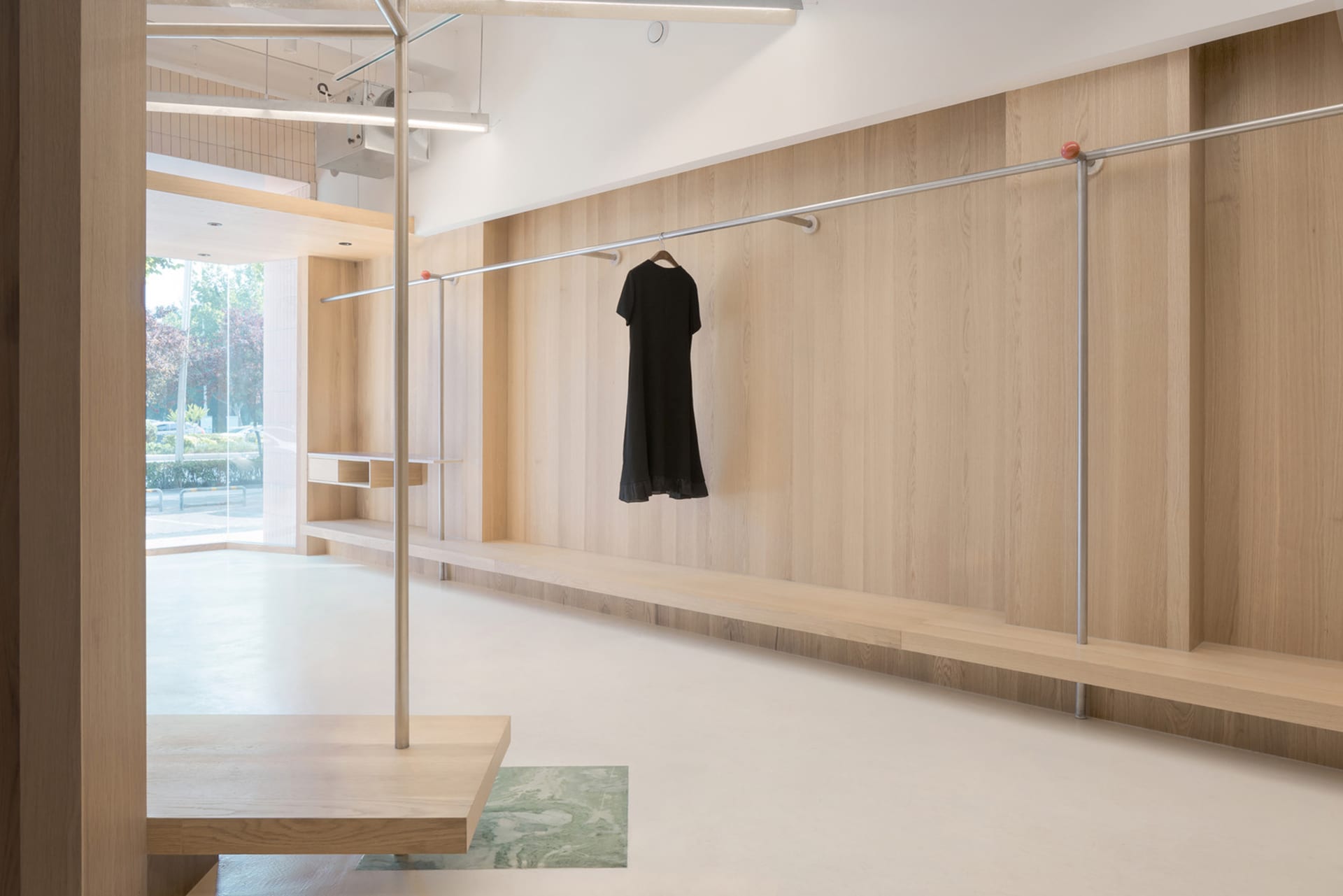 A modern wardrobe room with wooden walls and a hanging black dress.