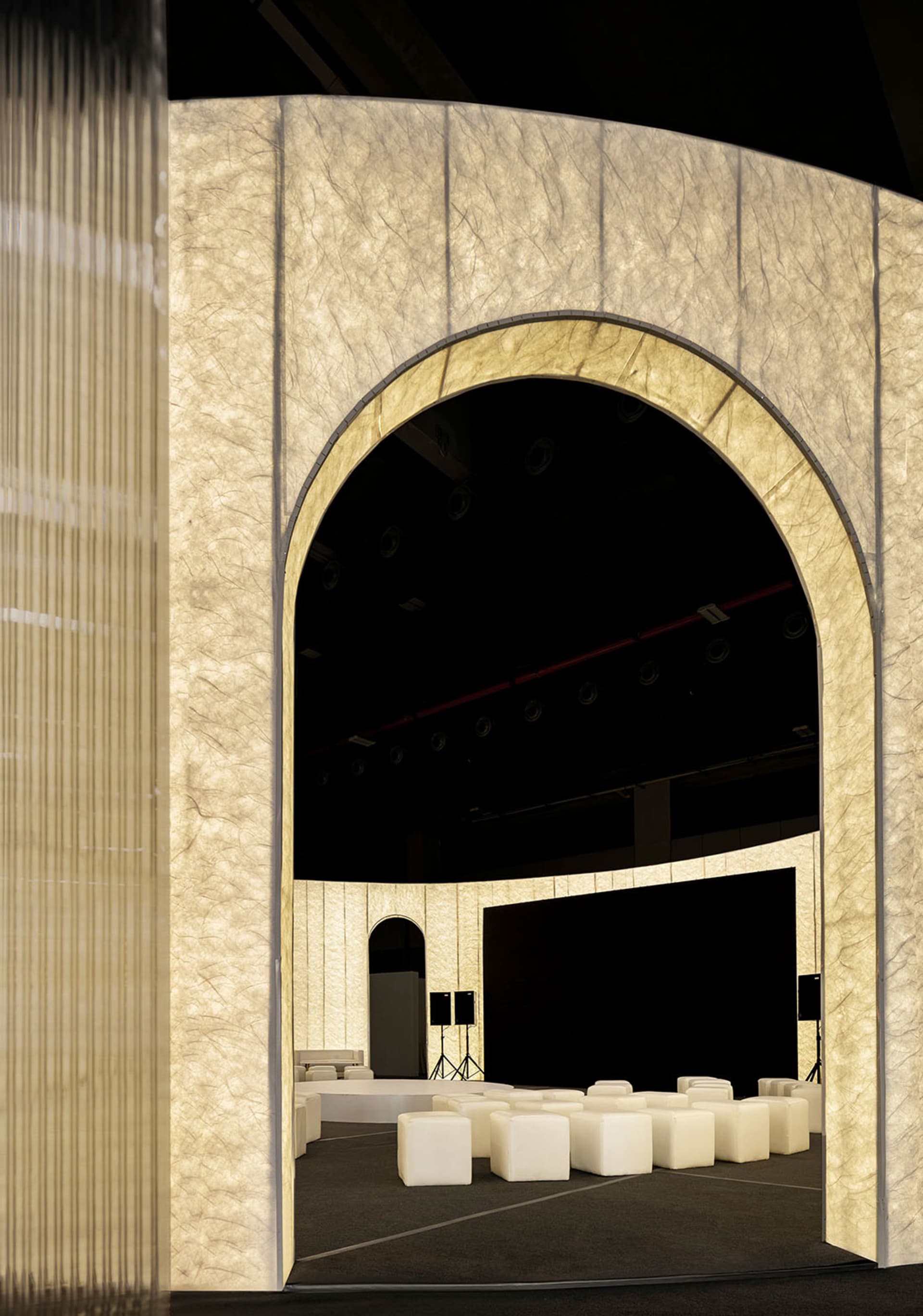A fabric-covered archway with a stage setup in the background.