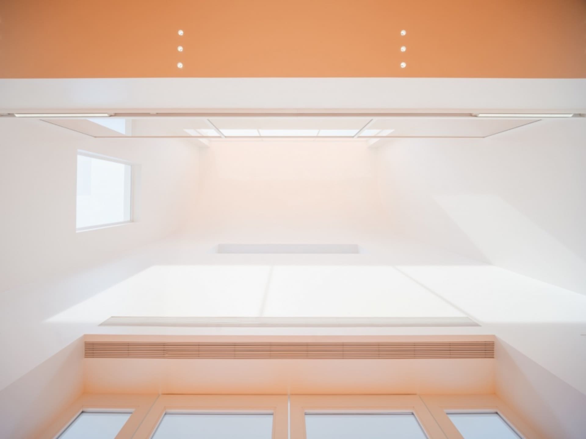 A modern interior space with white concrete walls and floors, white windows, and white ceiling.