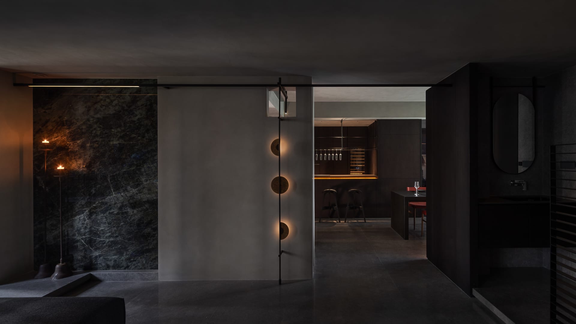 Modern kitchen interior with dark wood cabinetry and marble countertops.