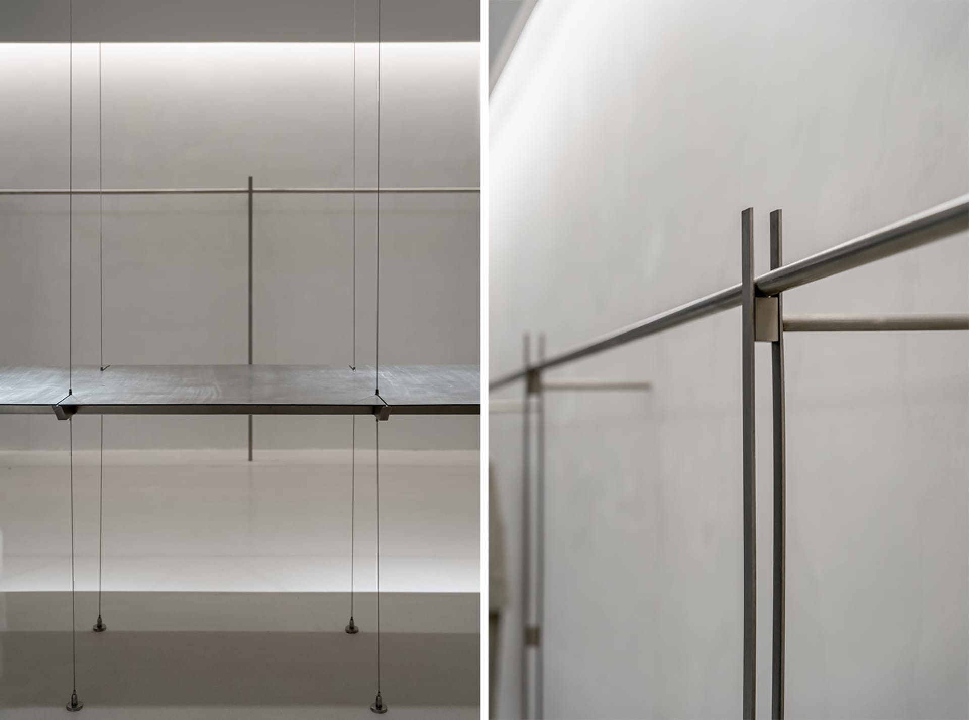 A minimalist metal shelf system supported by thin cables.