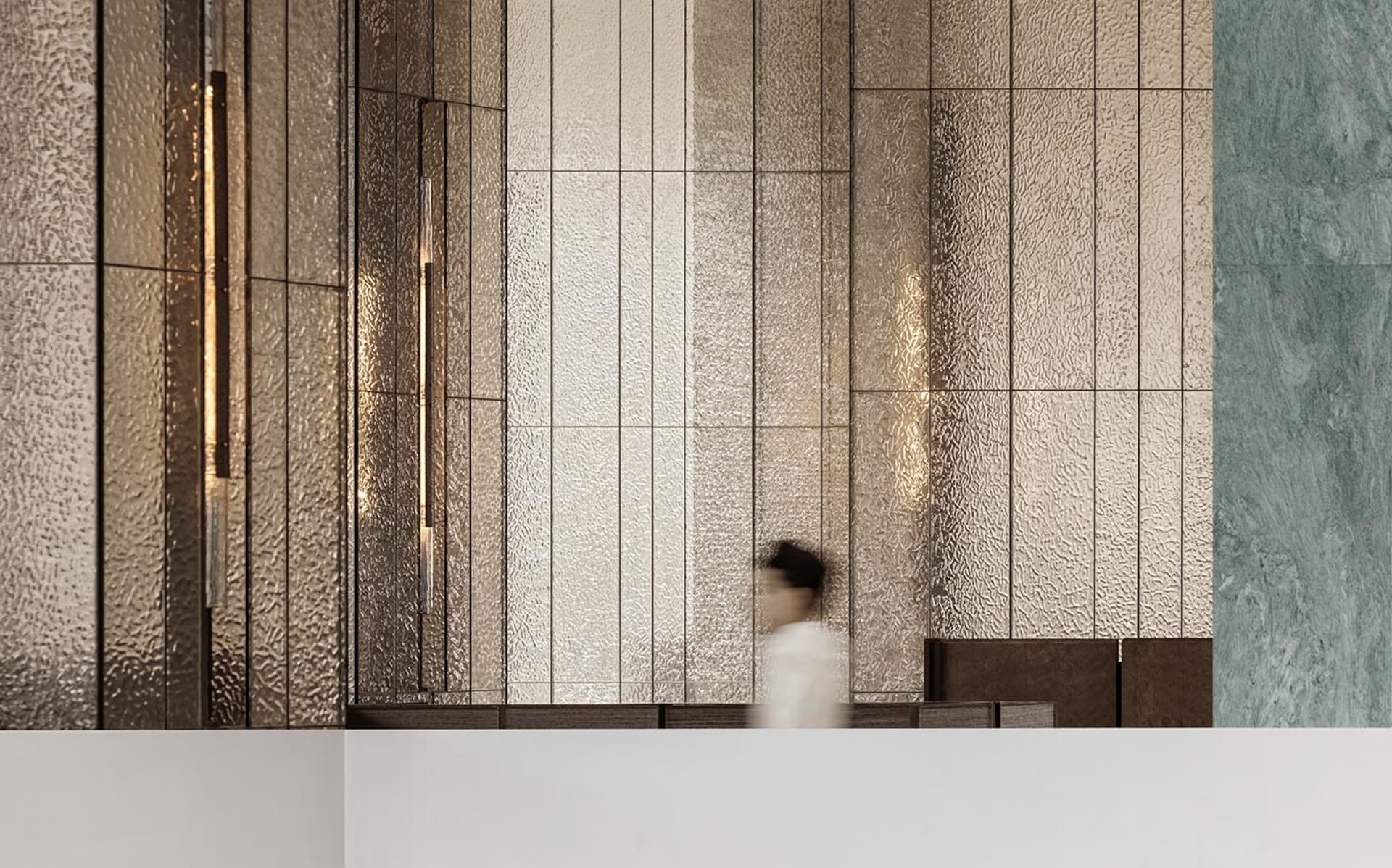 Modern lobby featuring glass and concrete panels, depicting a contemporary design aesthetic.