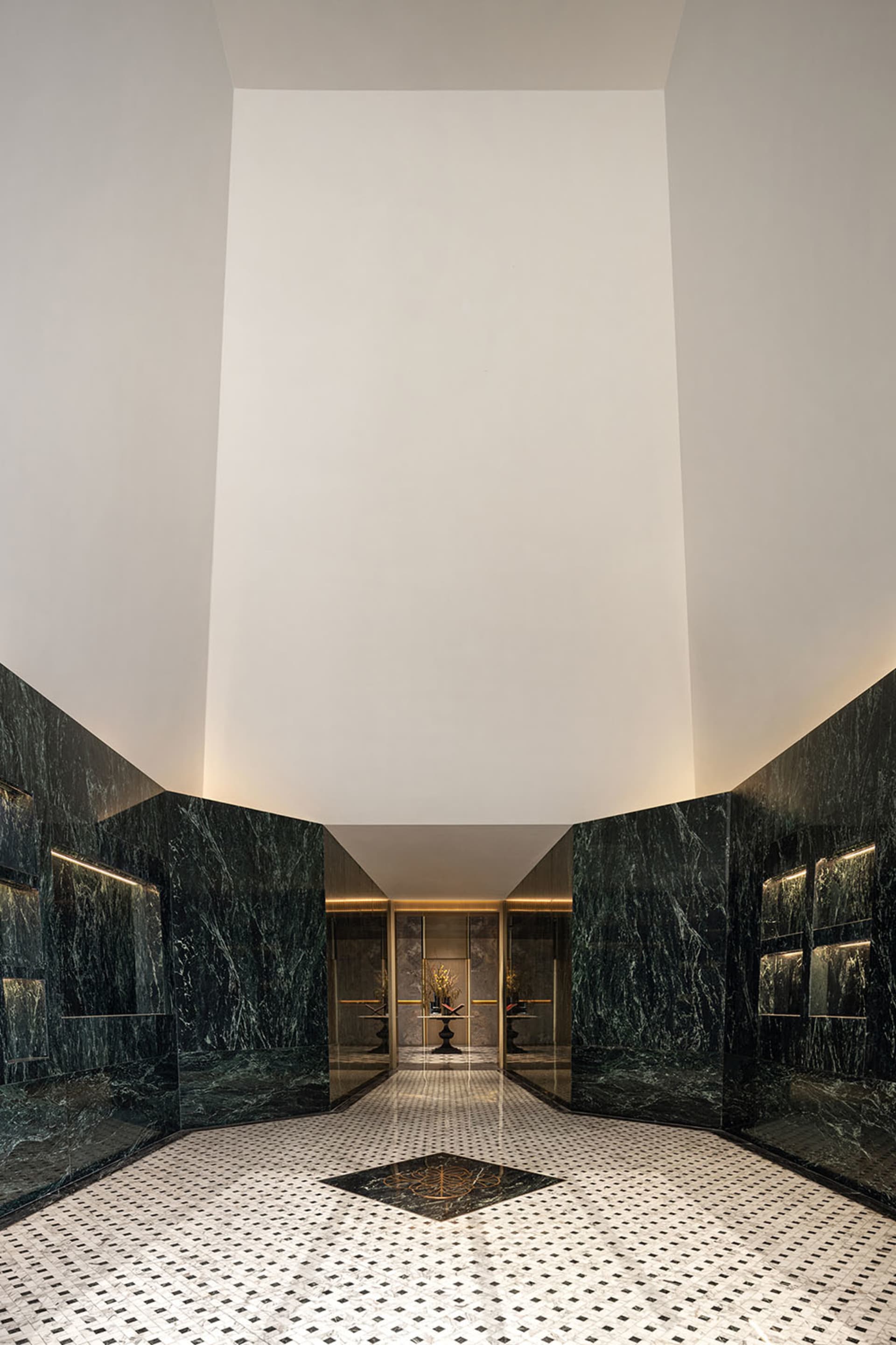 A modern lobby with marble walls and floor, featuring a geometric pattern and detailed finishes.