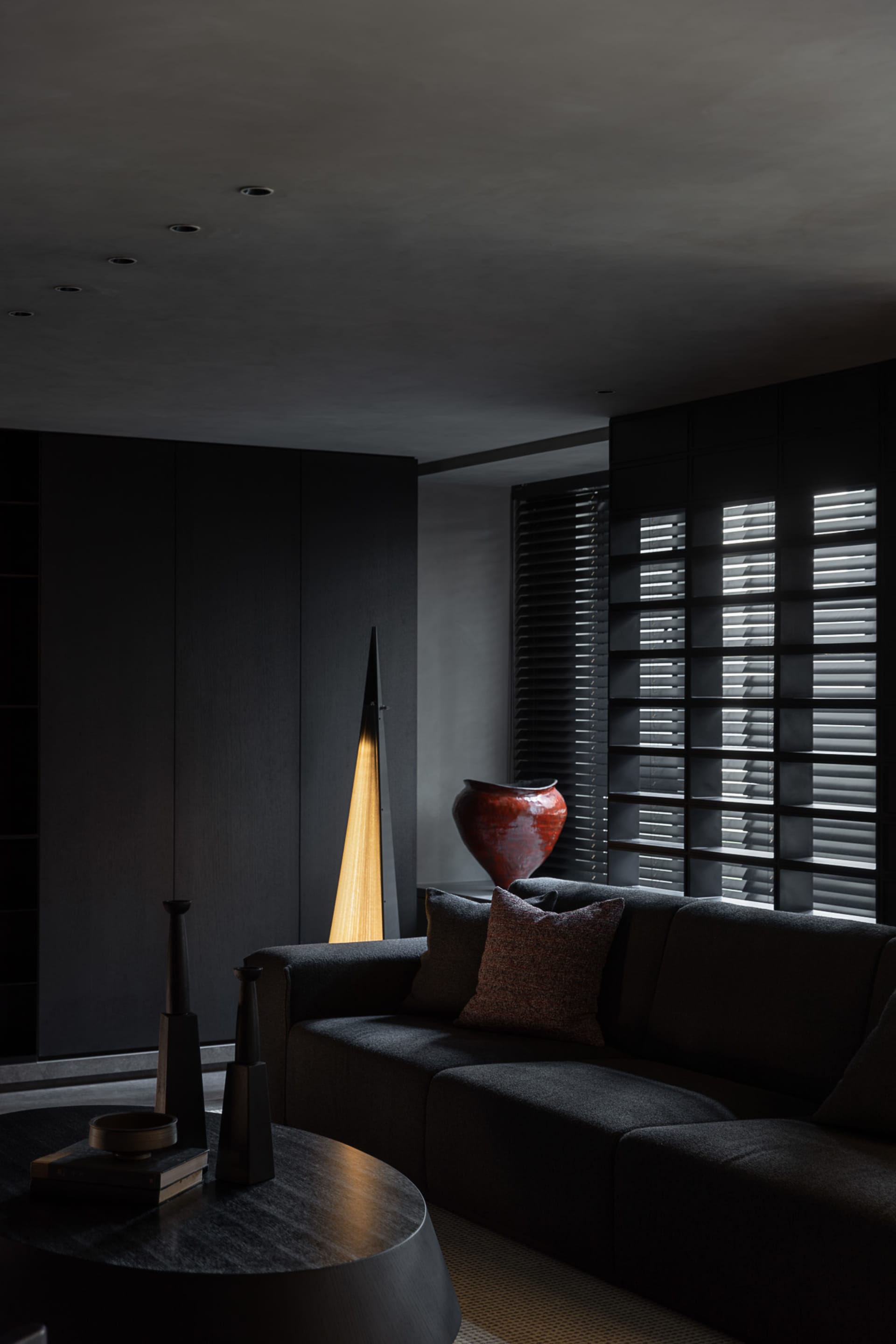 Modern living room with dark oak wood furniture and dark walls