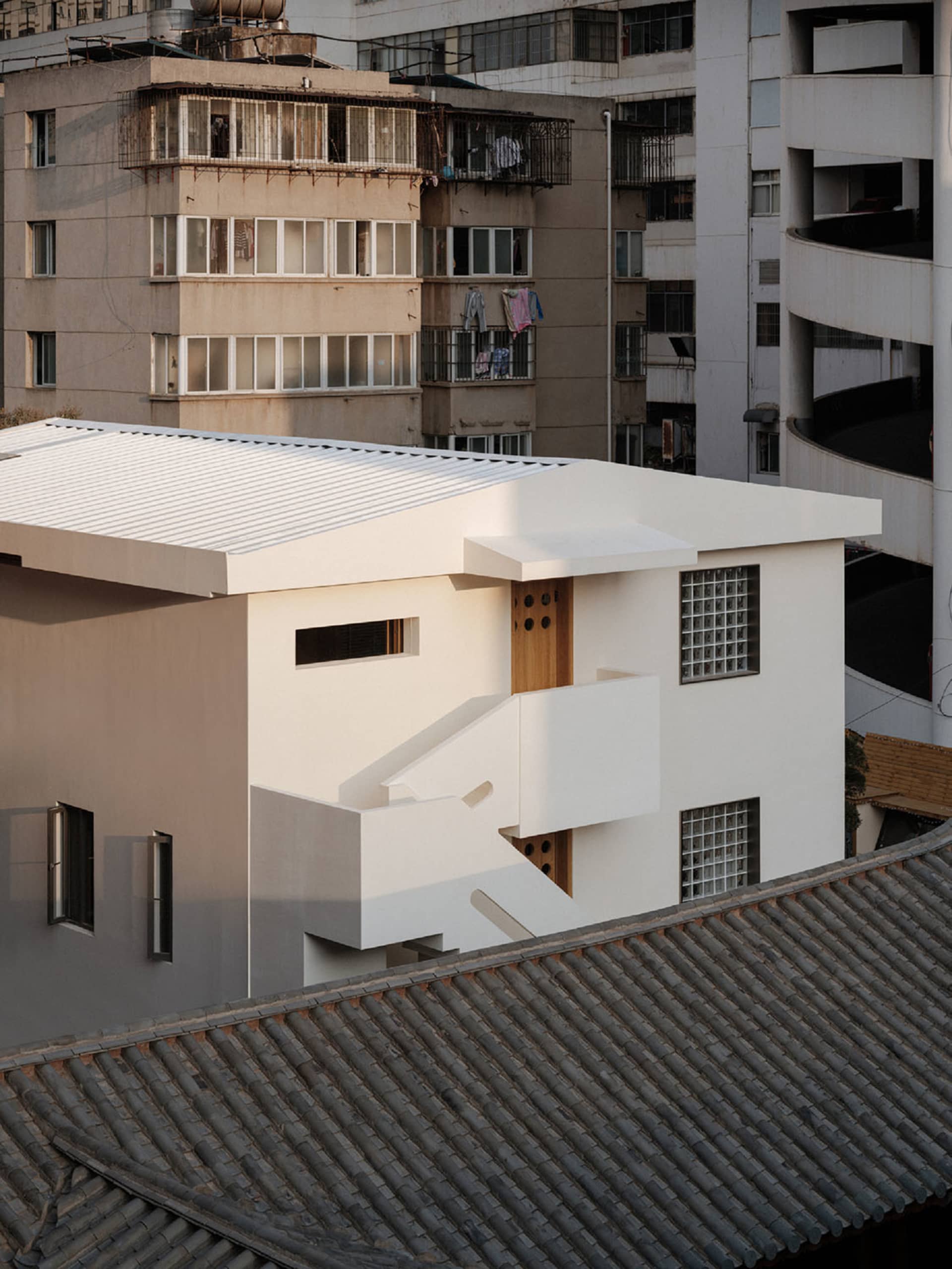 A modern concrete building with a minimalist design and clean lines, featuring large windows and a flat roof.