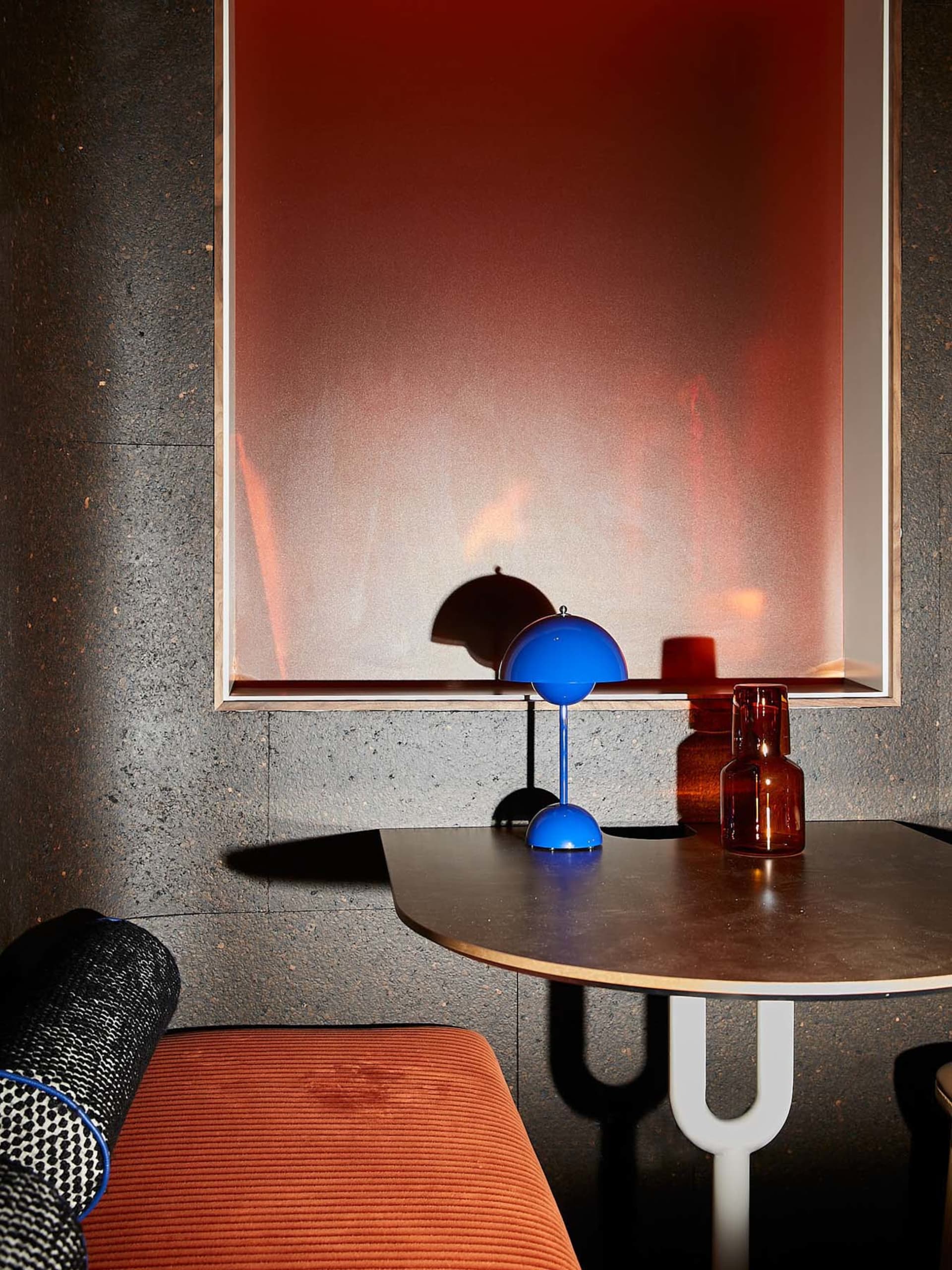 A modern interior featuring a metal table with a glass top and wooden legs.