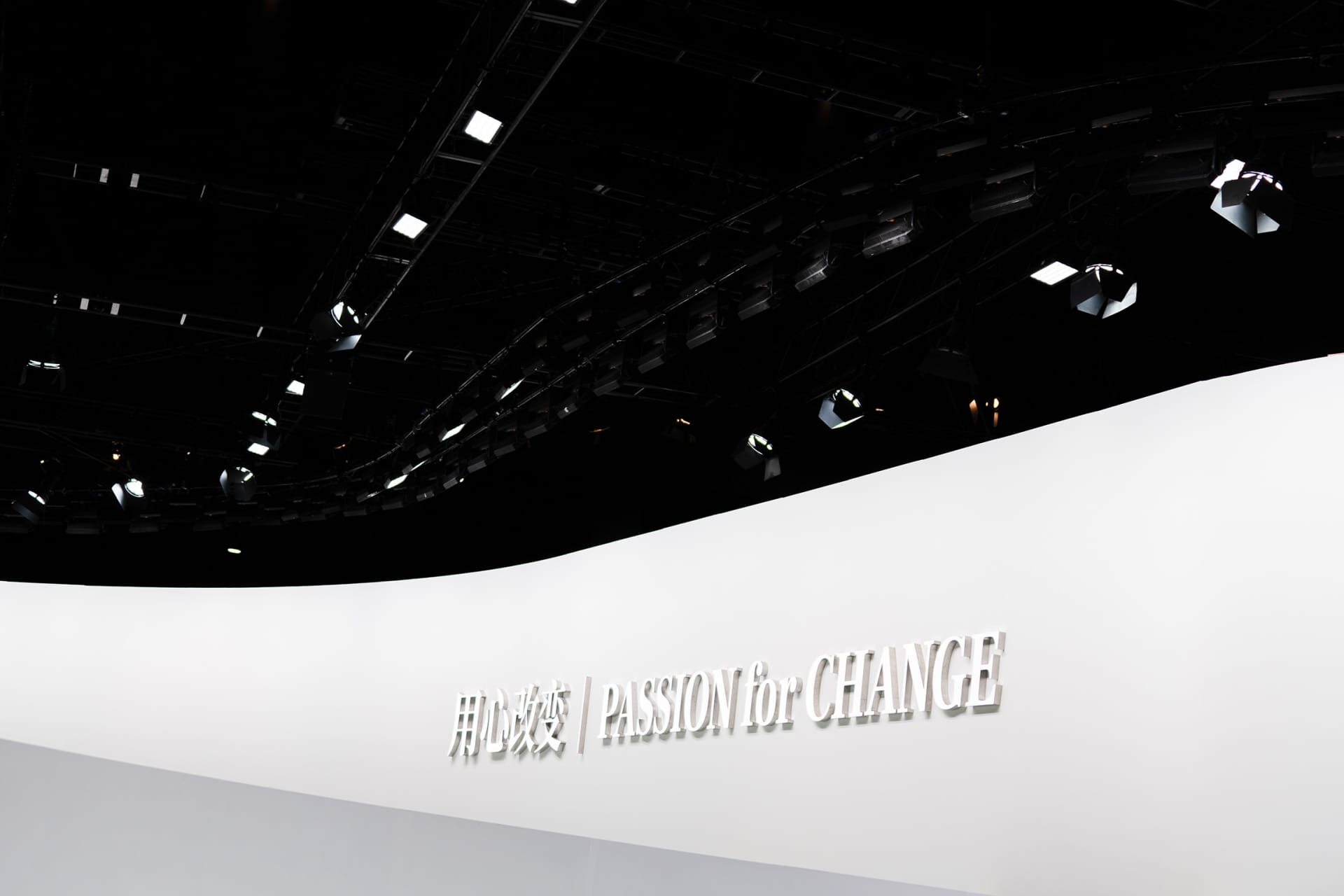 A minimalist event stage with the text 'PASSION for CHANGE' written on a textured canvas backdrop.