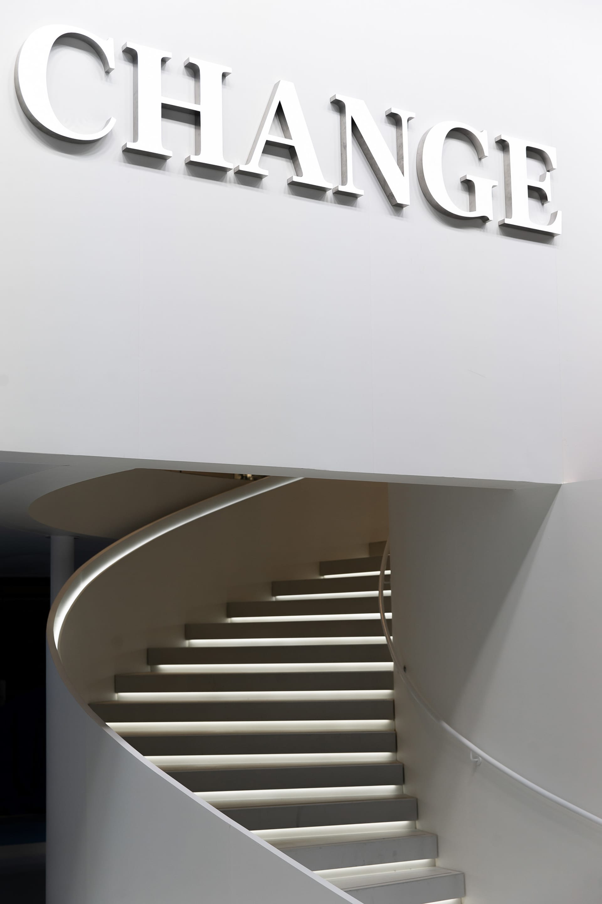 Modern, metallic staircase with illuminated steps and a sleek design.