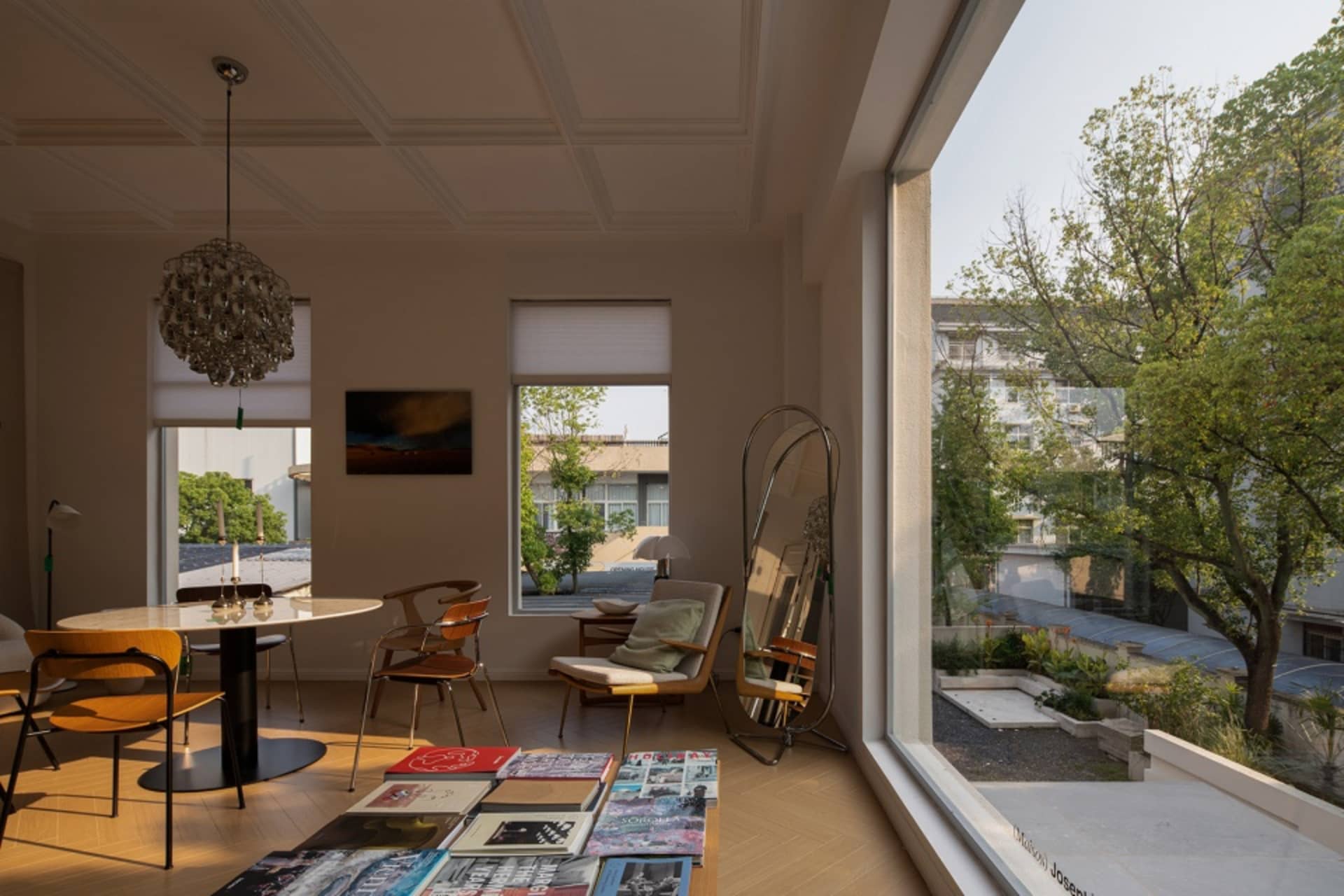 Interior design of a modern living room with wooden flooring, large windows, and a clear view of the outdoors.